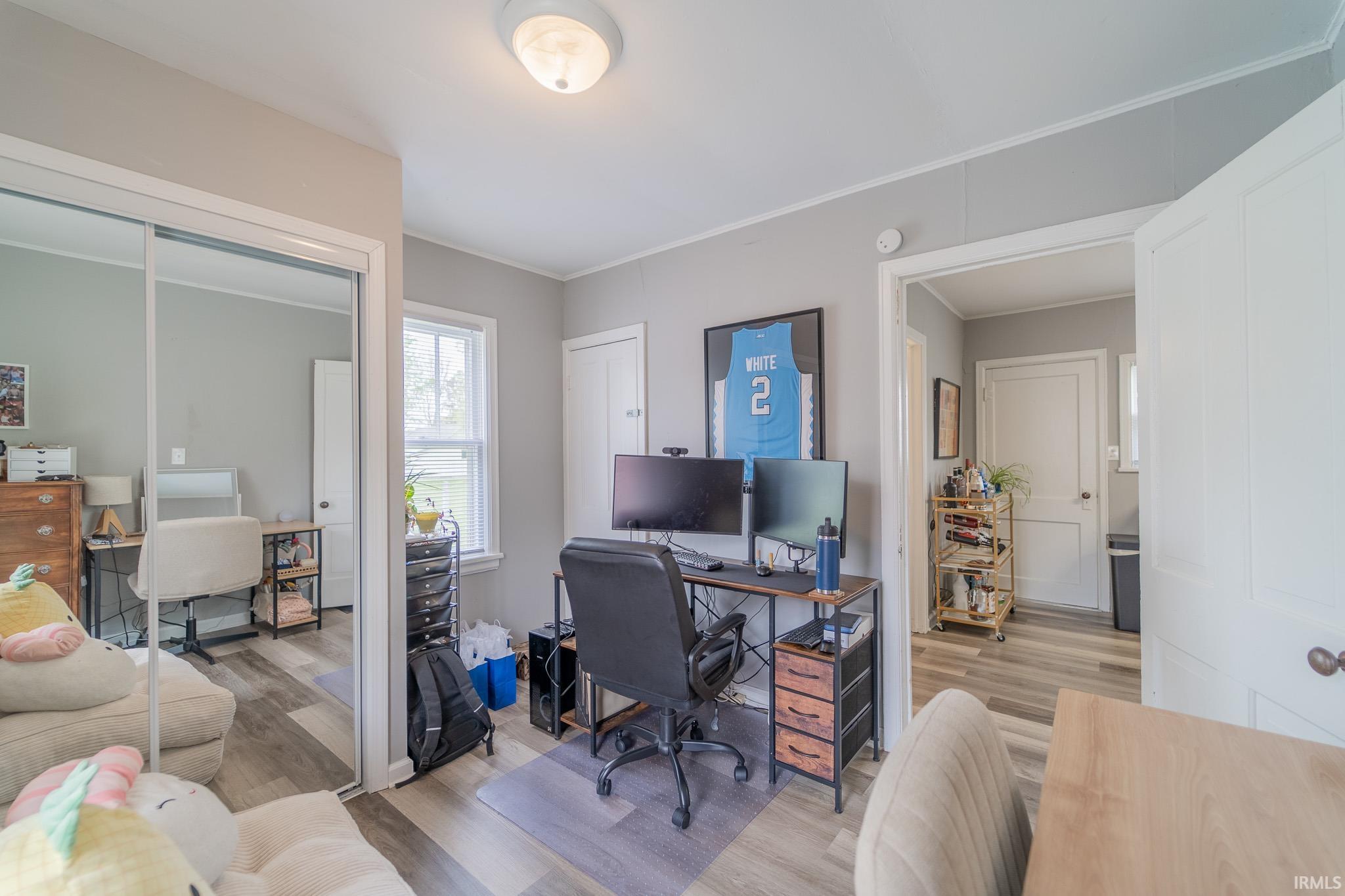 Room featuring wood-finish flooring, light grey painted walls, and a ceiling light fixture