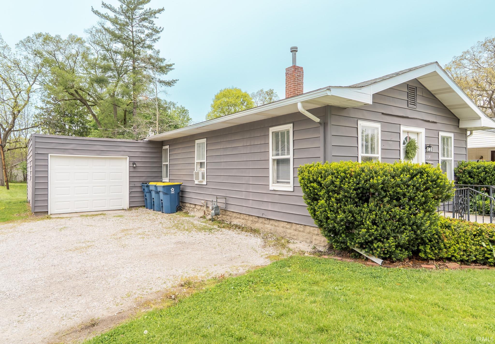 Gray horizontal siding exterior with white trim windows and a prominent front entry