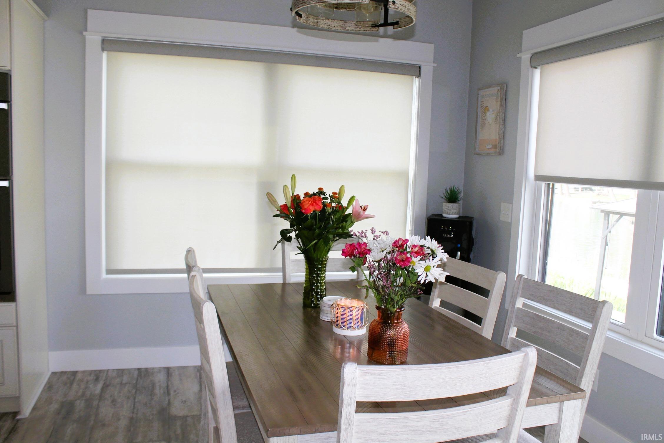 Dining area with wood-finish flooring, light gray walls, and white trim
