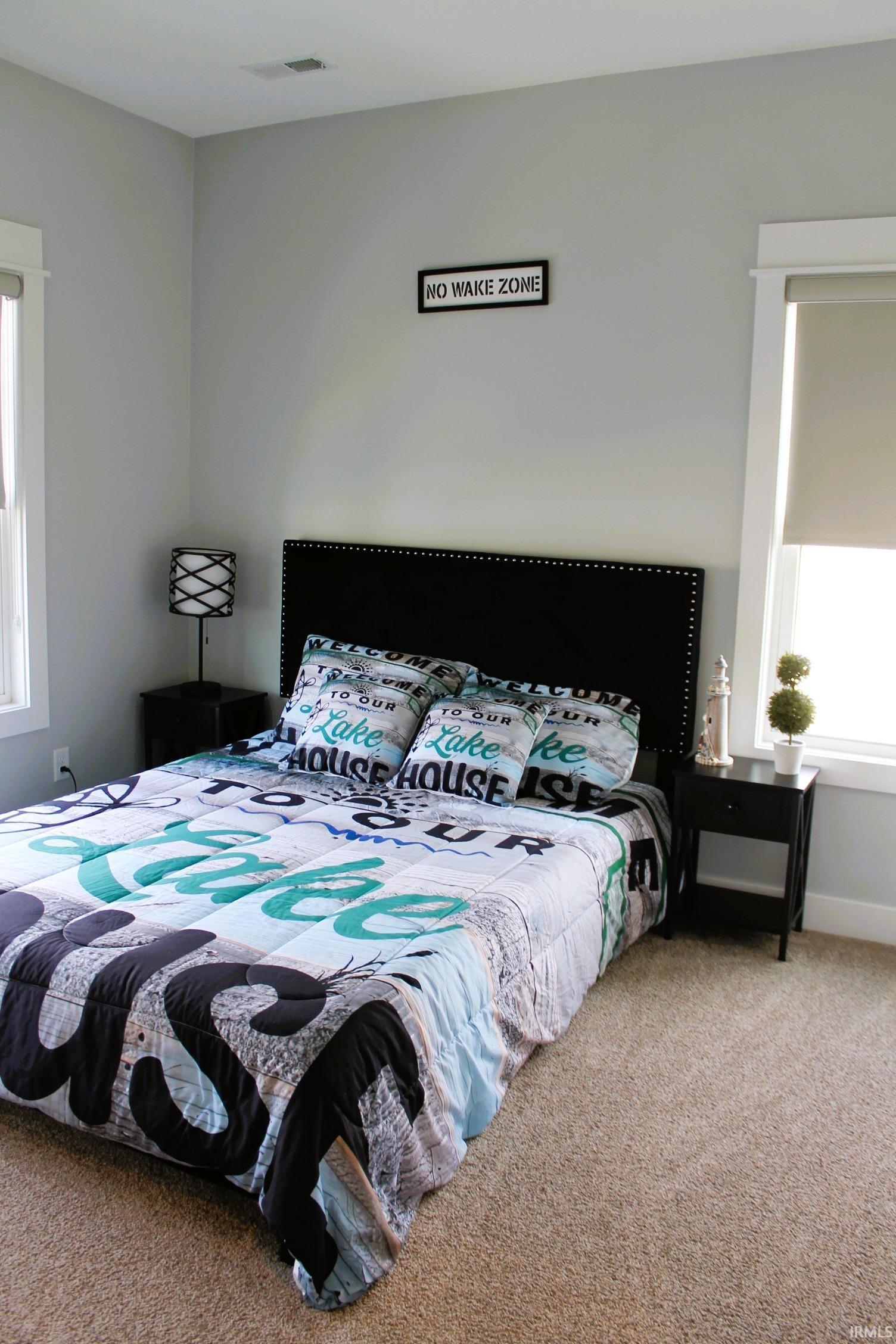Bedroom featuring light gray wall paint and neutral-toned carpeting