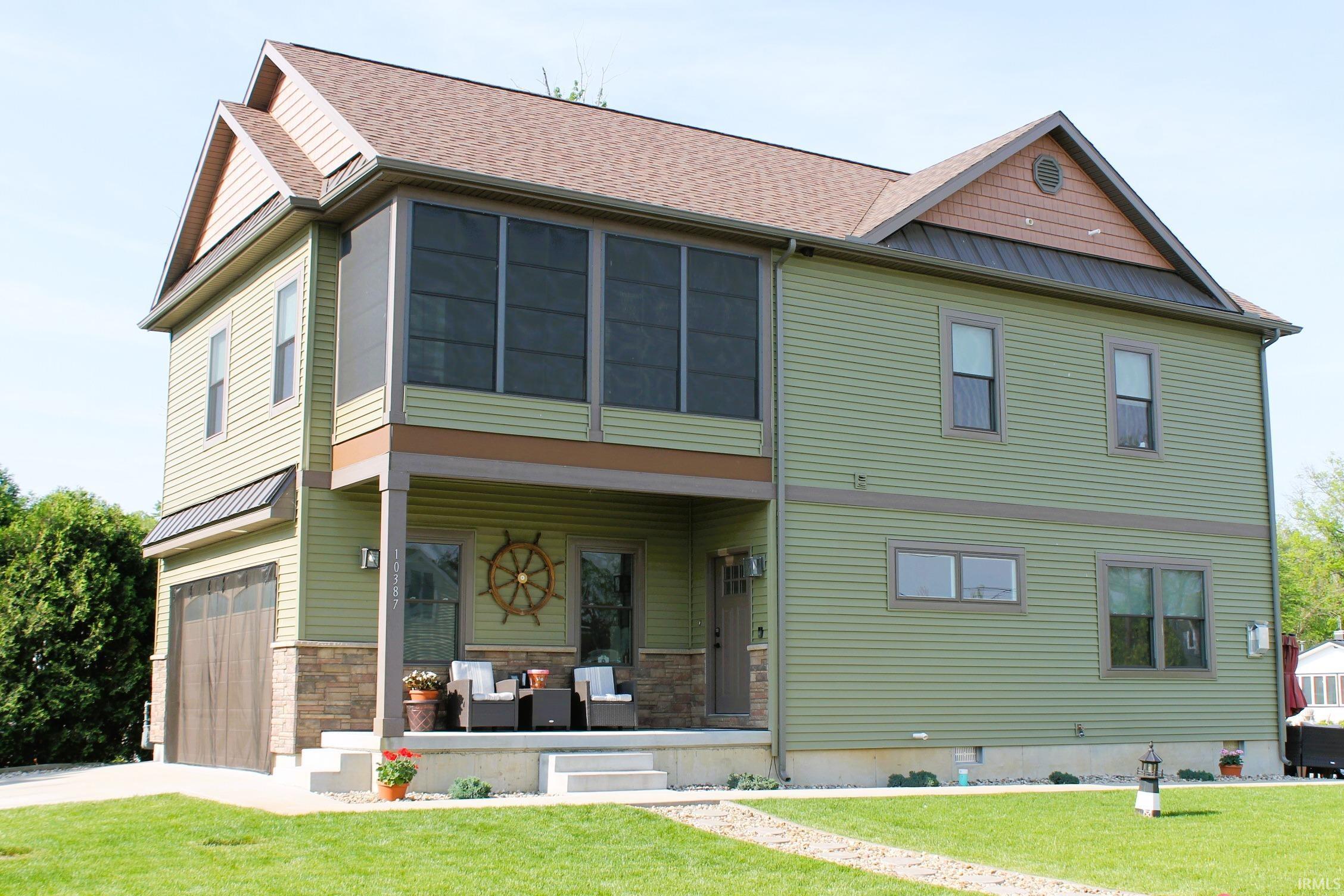 Two-story exterior with light green siding and a brown shingle roof