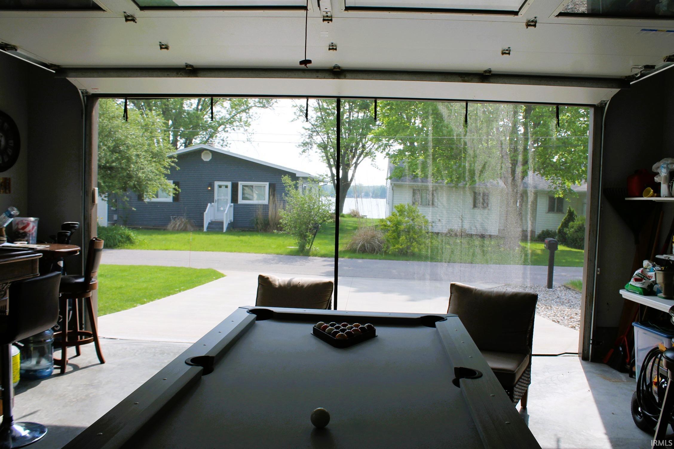 Garage door opening featuring a transparent screen, concrete flooring, and built-in shelving