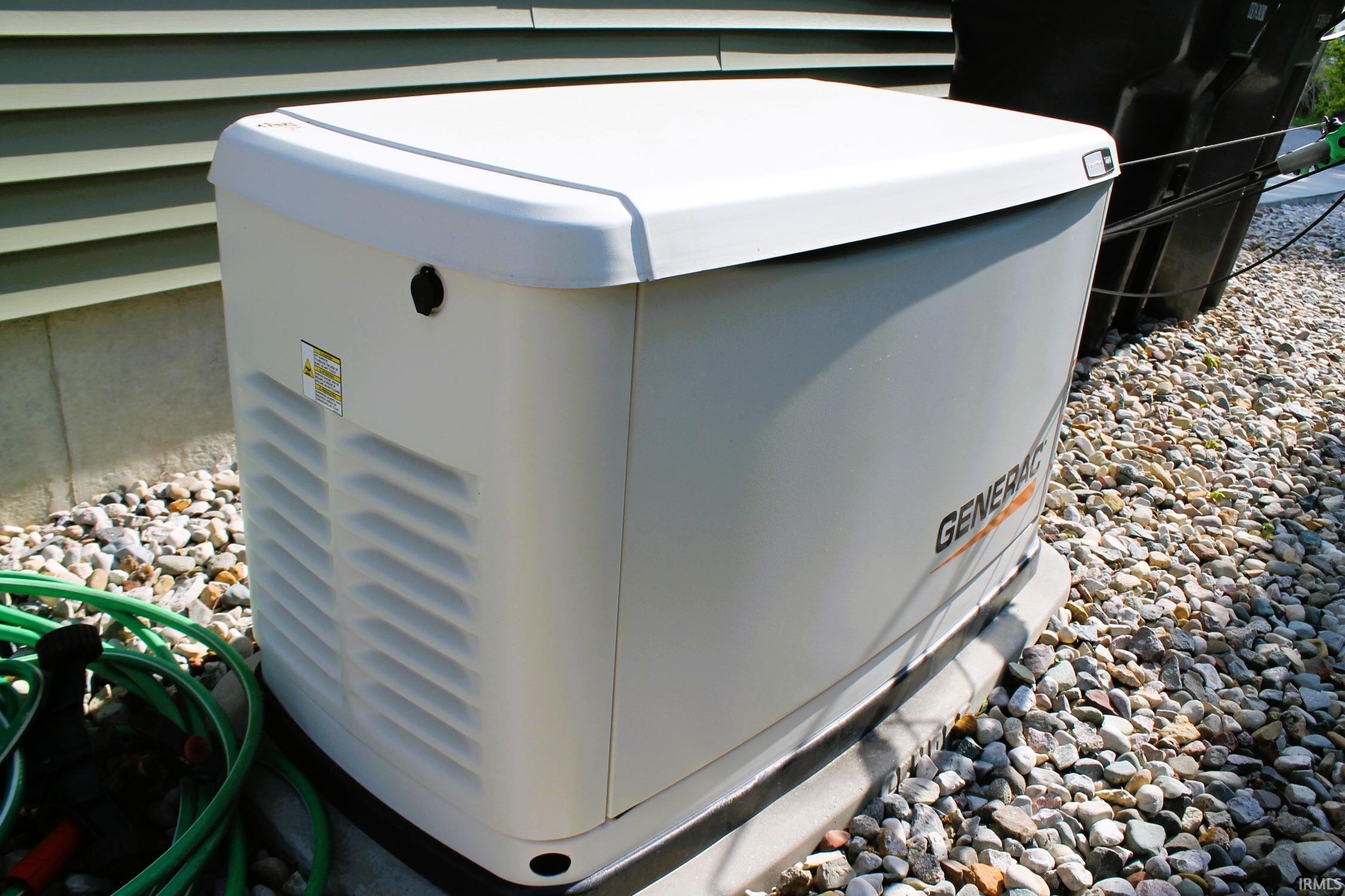 Standby generator unit situated on a gravel bed beside the property's siding