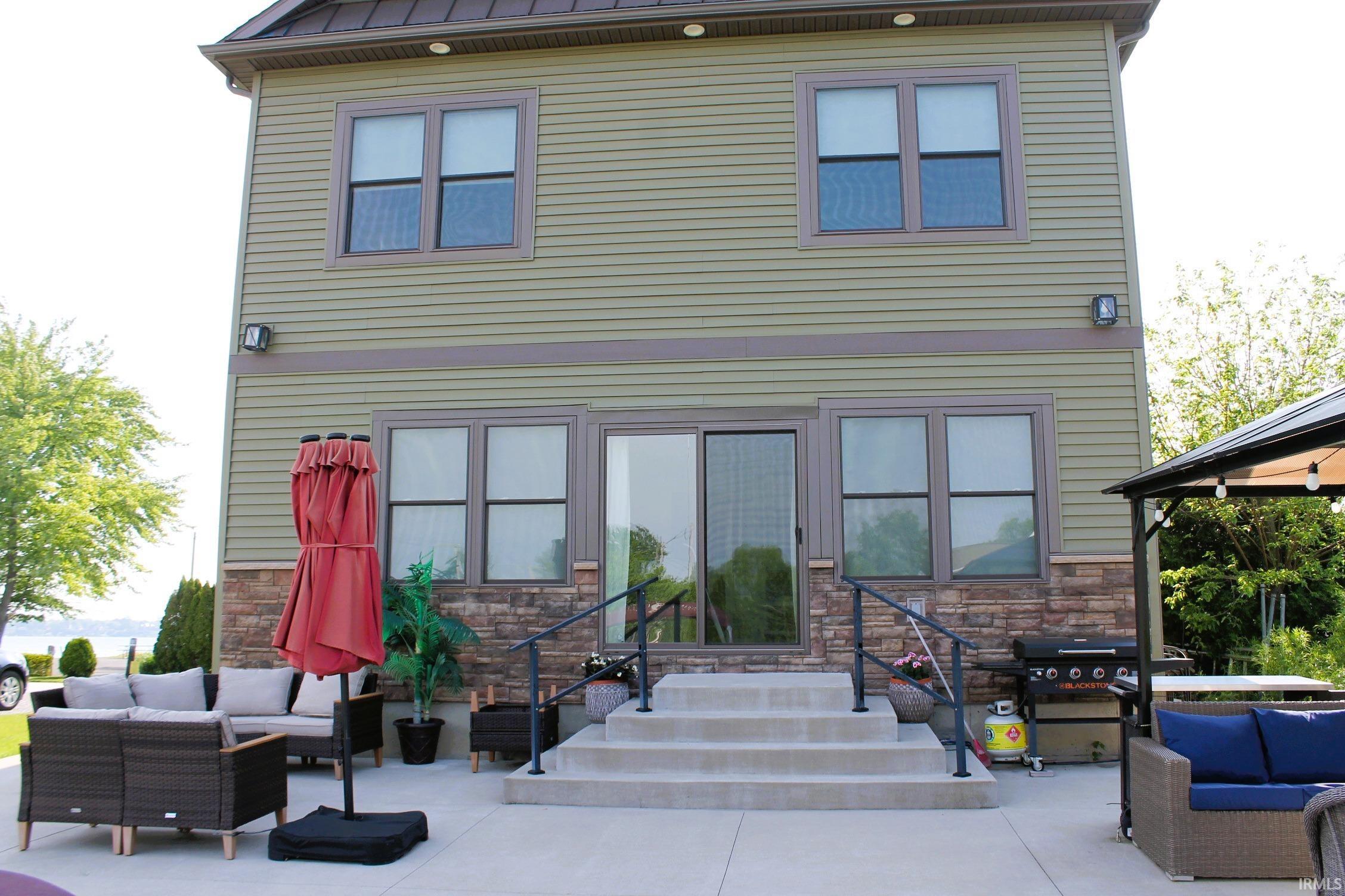 Rear exterior of a two-story residence featuring horizontal siding and stone veneer