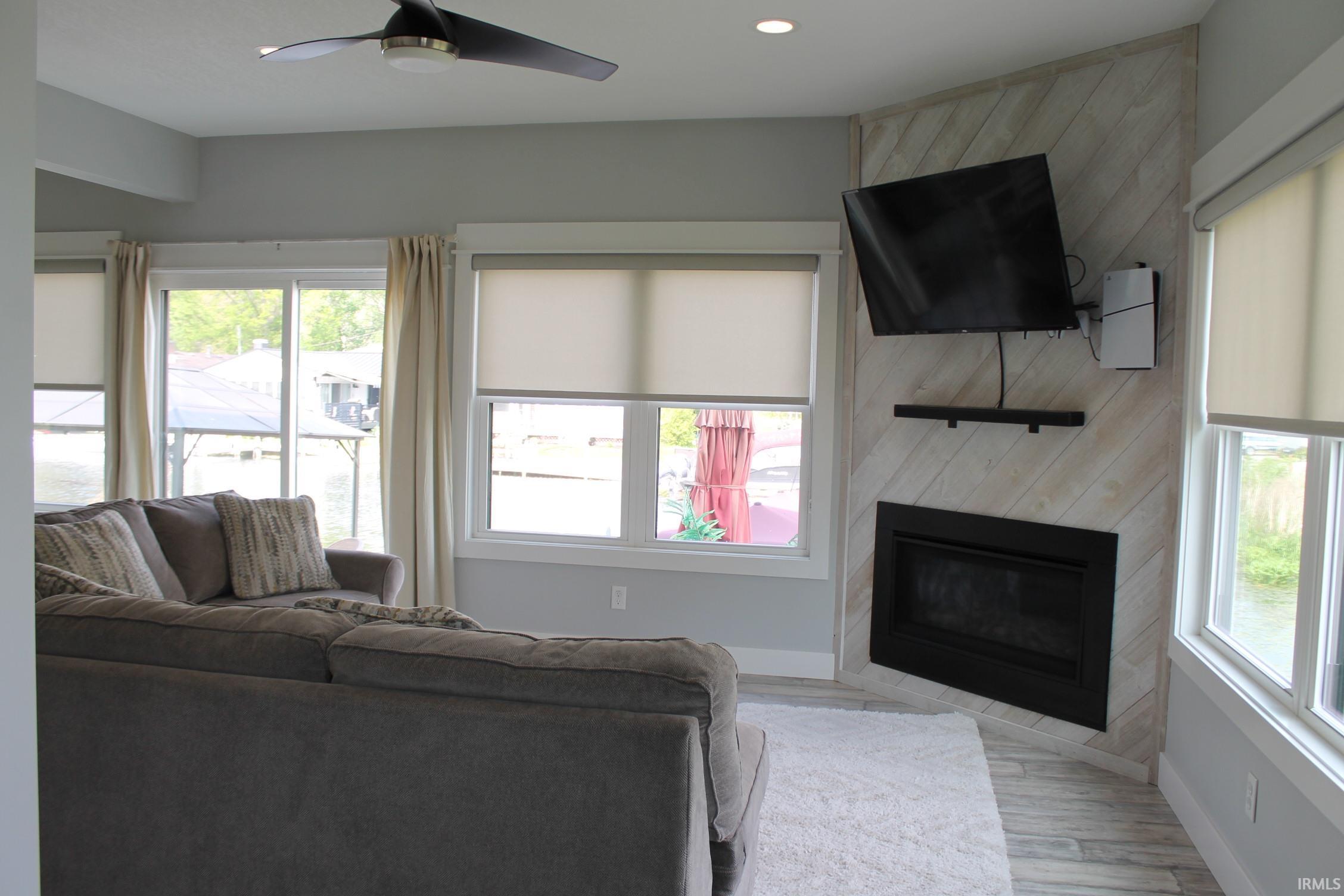 Living area featuring a corner-mounted fireplace with a diagonal wood-finish accent wall