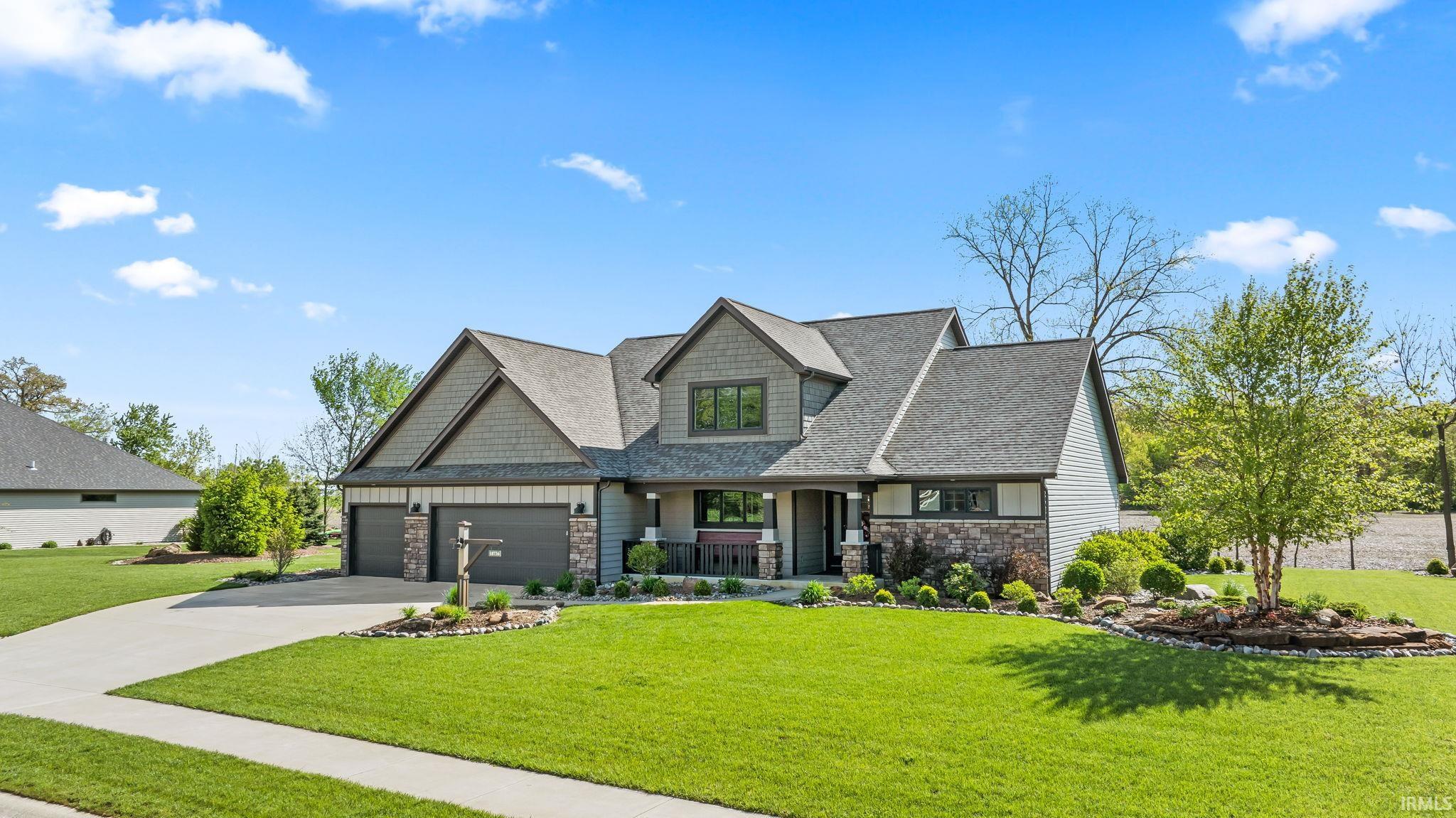 Craftsman-style residence featuring a multi-gabled roofline and a combination of horizontal siding, shake siding, and stone accents