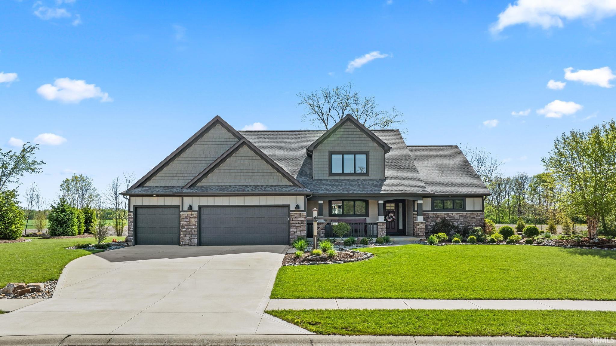Modern craftsman-style residence featuring a multi-gabled roofline and a combination of stone and siding exterior finishes
