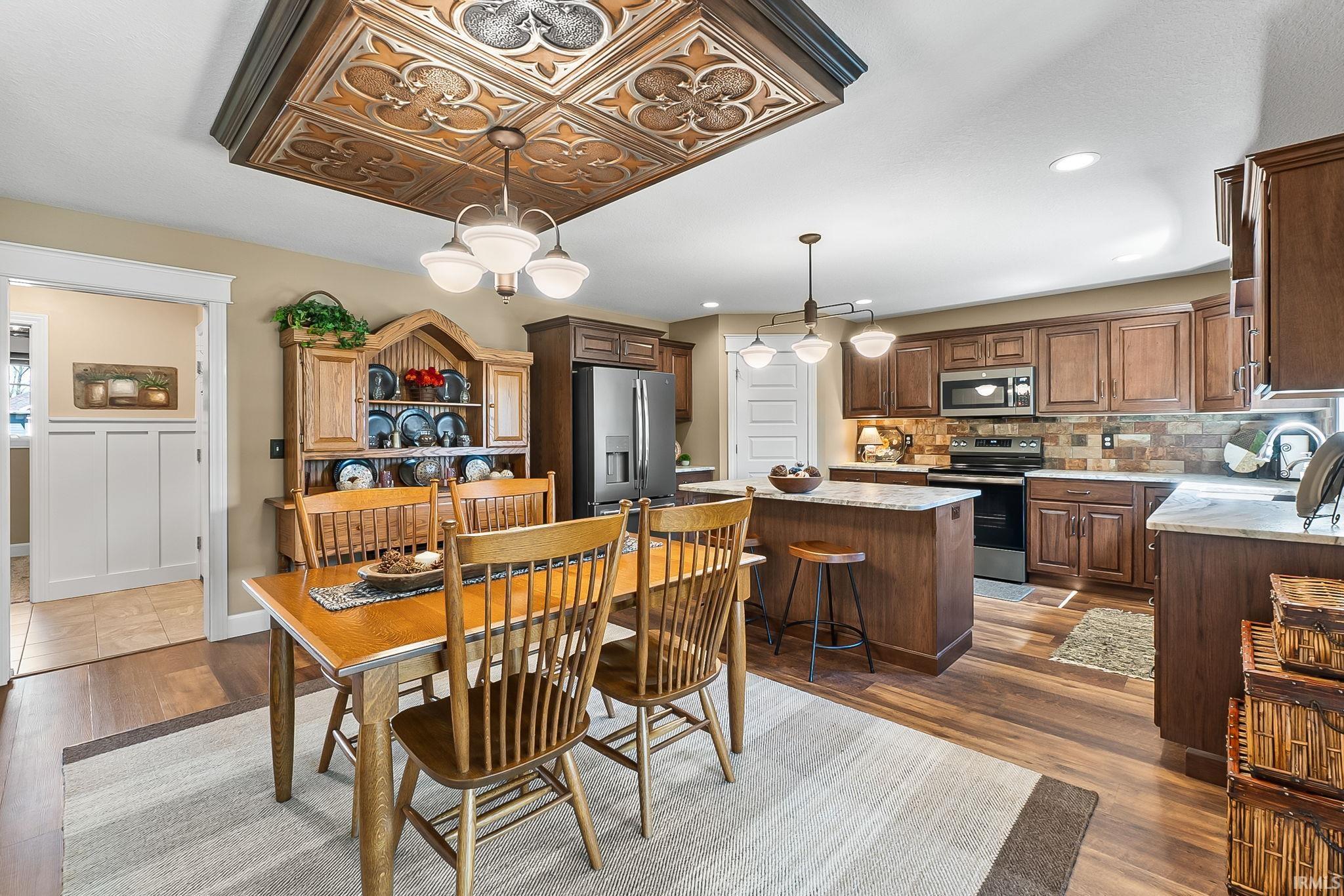 Open-concept kitchen and dining area with wood-finish flooring