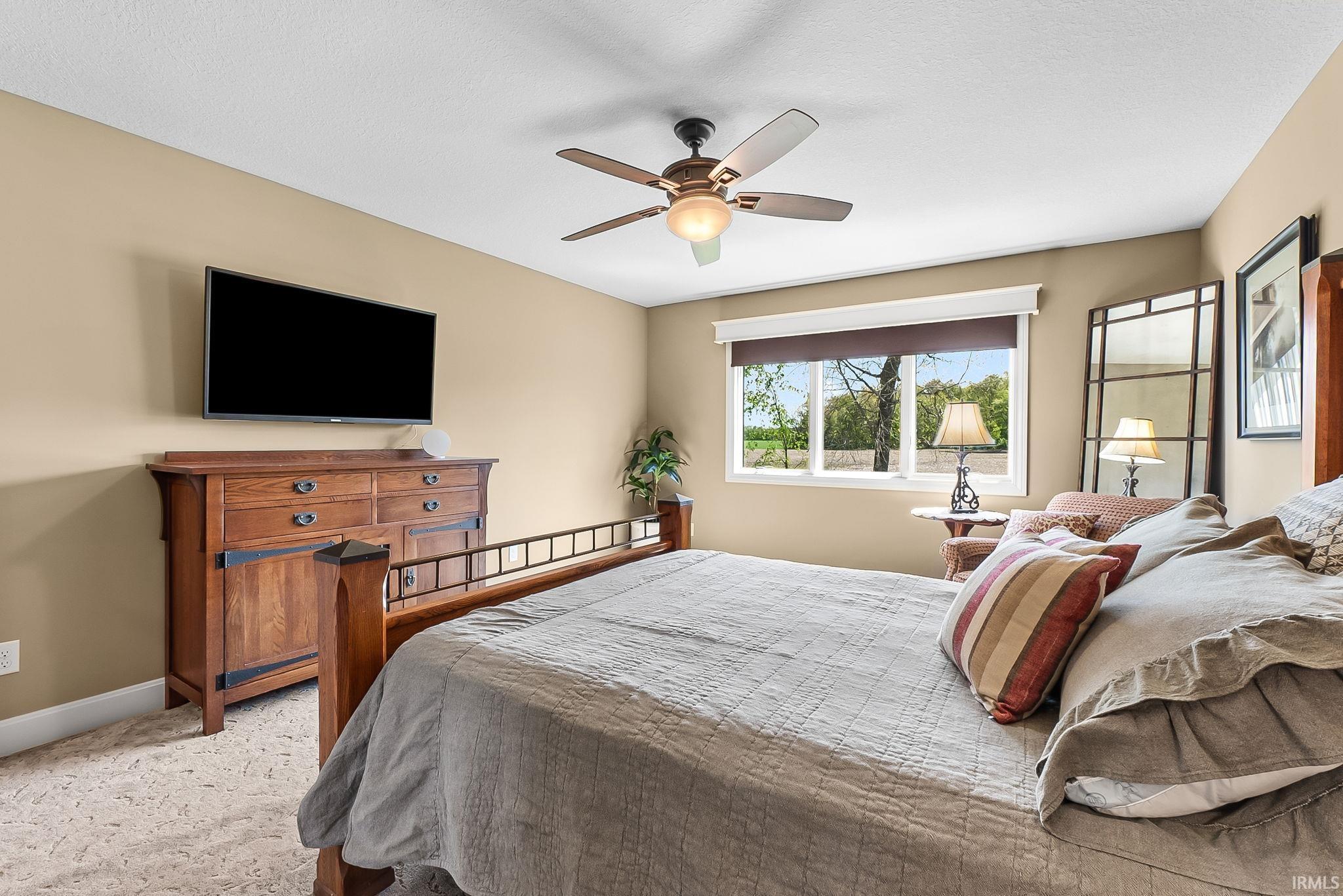 Inviting room featuring a multi-pane window, carpet flooring, and a ceiling fan with integrated lighting