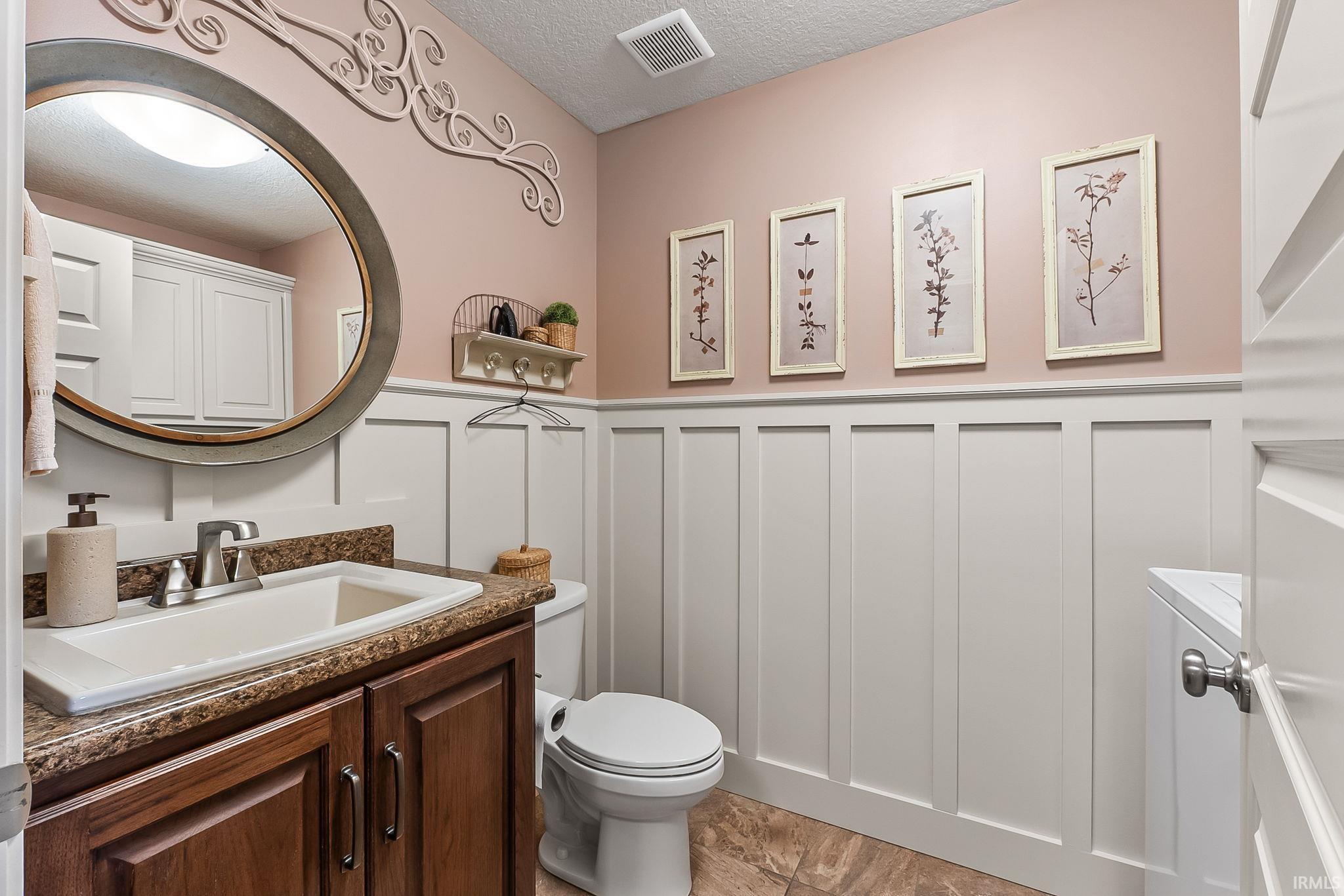 Bathroom with wainscoting and a dark wood-finish vanity