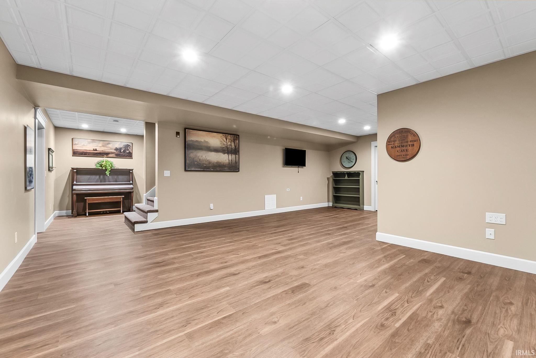 Spacious lower level featuring wood-finish flooring, recessed lighting, and light beige wall paint