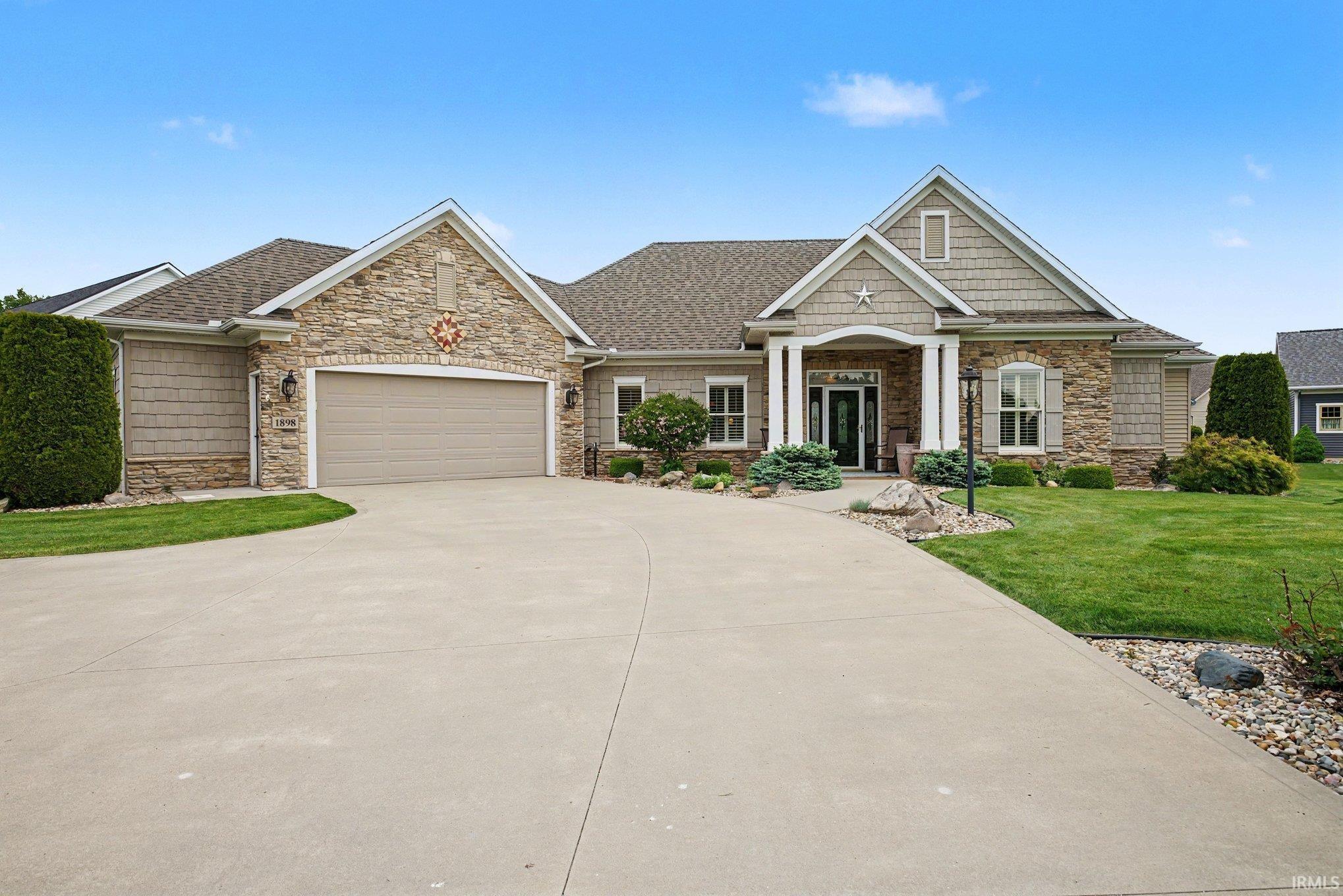 Expansive concrete driveway leading to a two-car garage