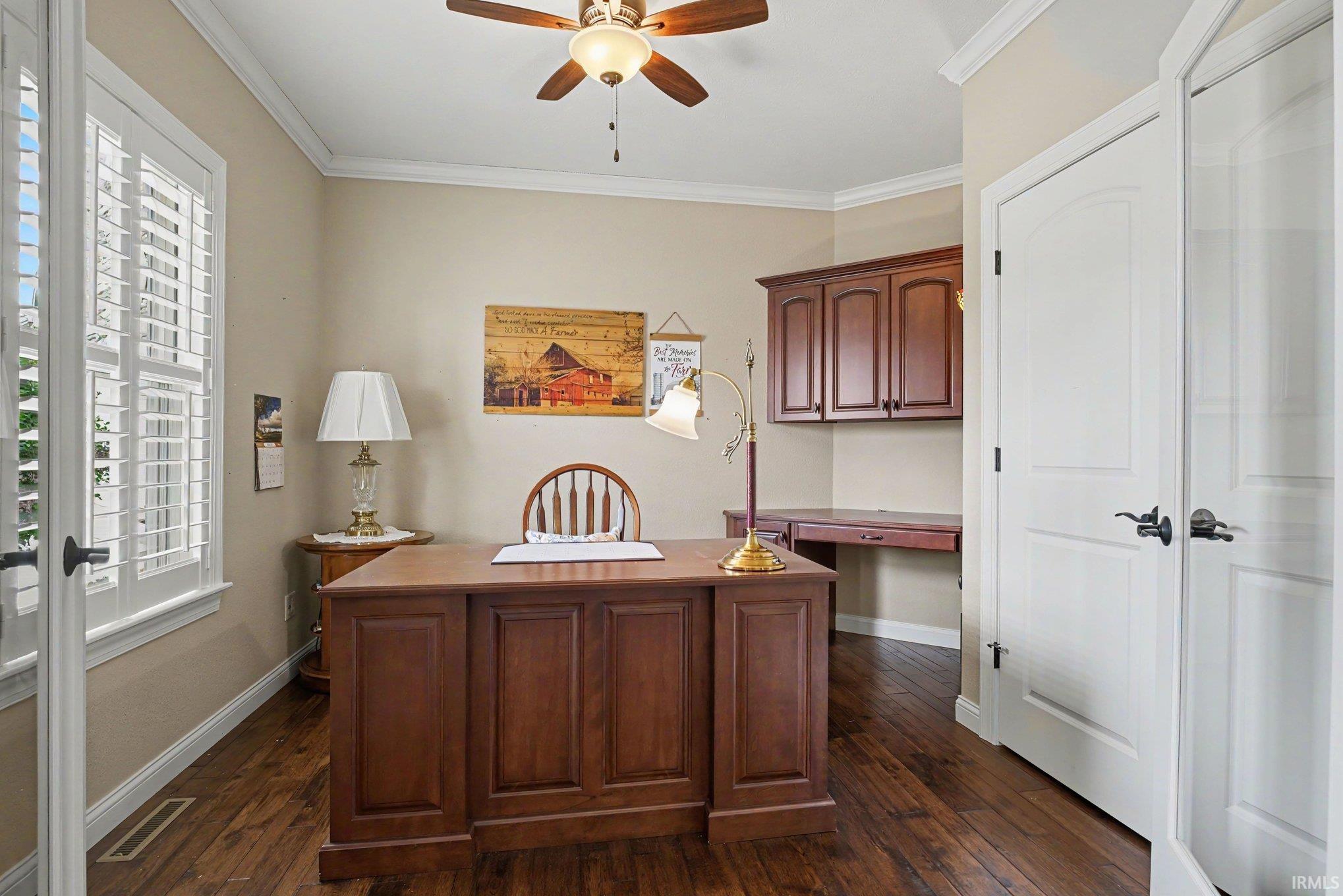 Dedicated space featuring wood-finish flooring, a ceiling fan with integrated lighting, and crown molding