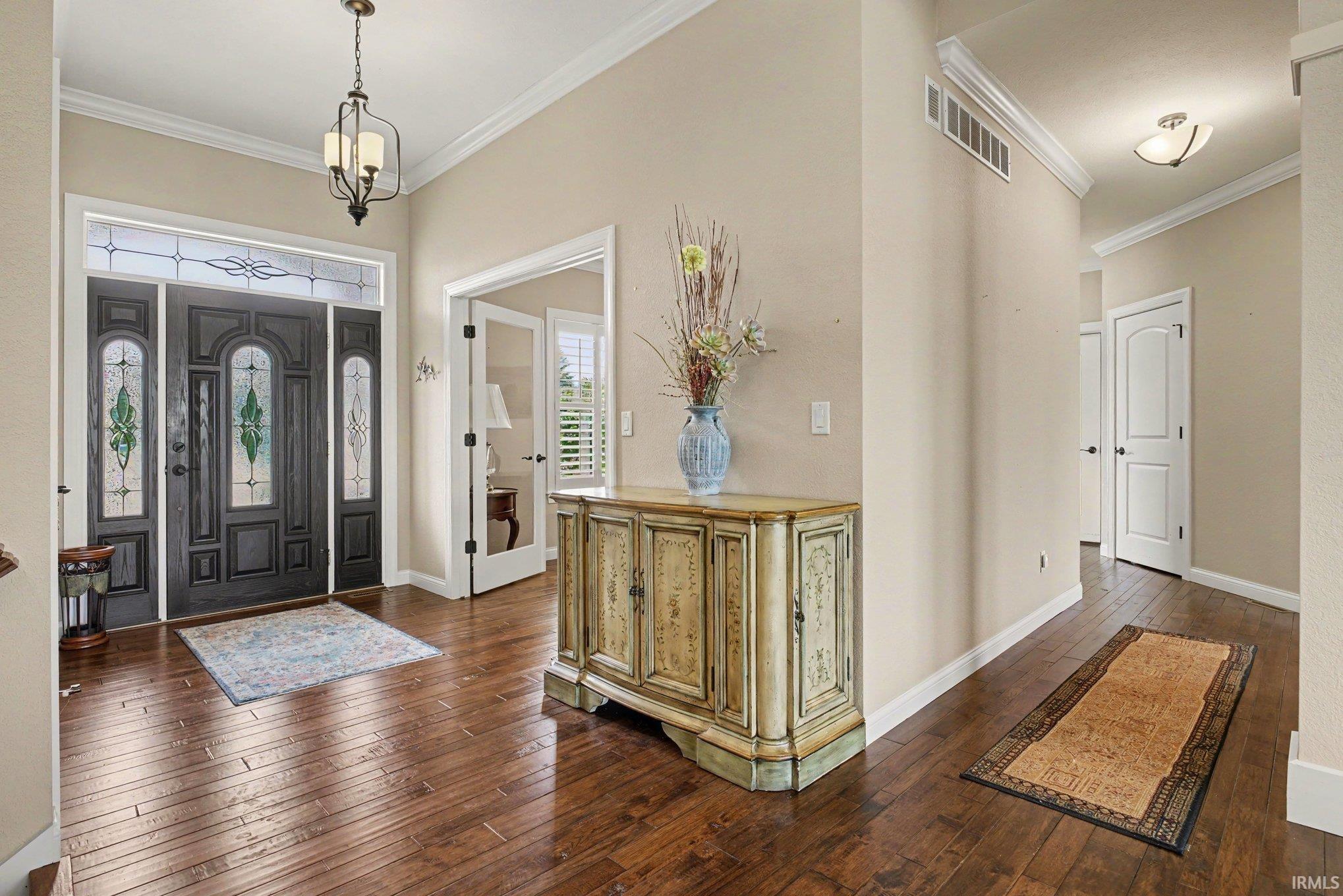 Entryway featuring a dark wood-finish door with decorative glass inserts and a transom window