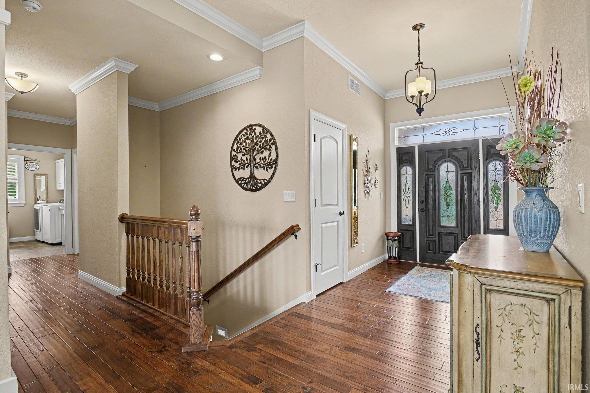 Grand entryway featuring a dark wood front door with decorative glass inserts and sidelights