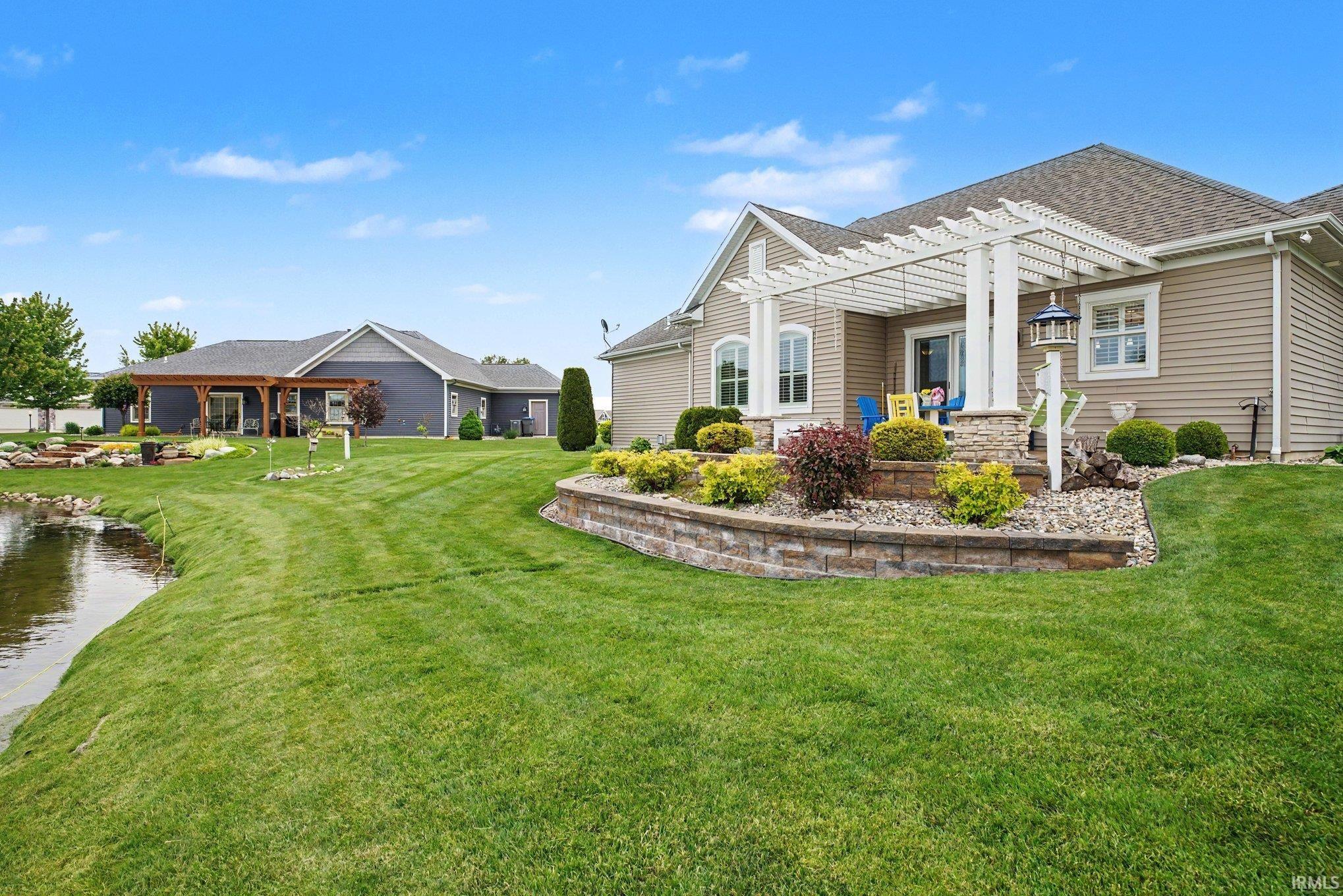Expansive lawn with a retaining wall featuring integrated landscaping
