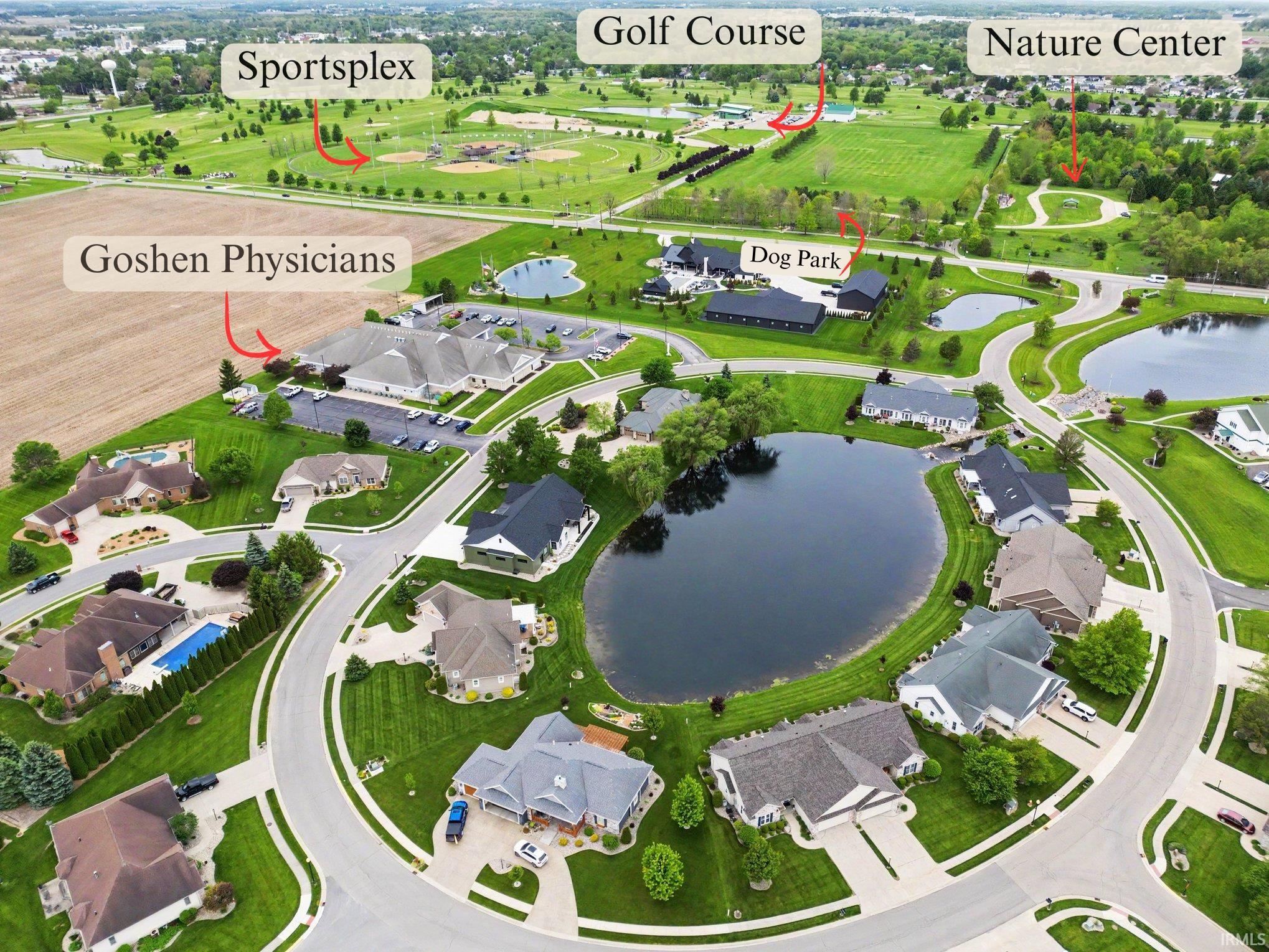 Aerial perspective showcasing a residential community with winding roads and numerous homes, many featuring private driveways and manicured lawns