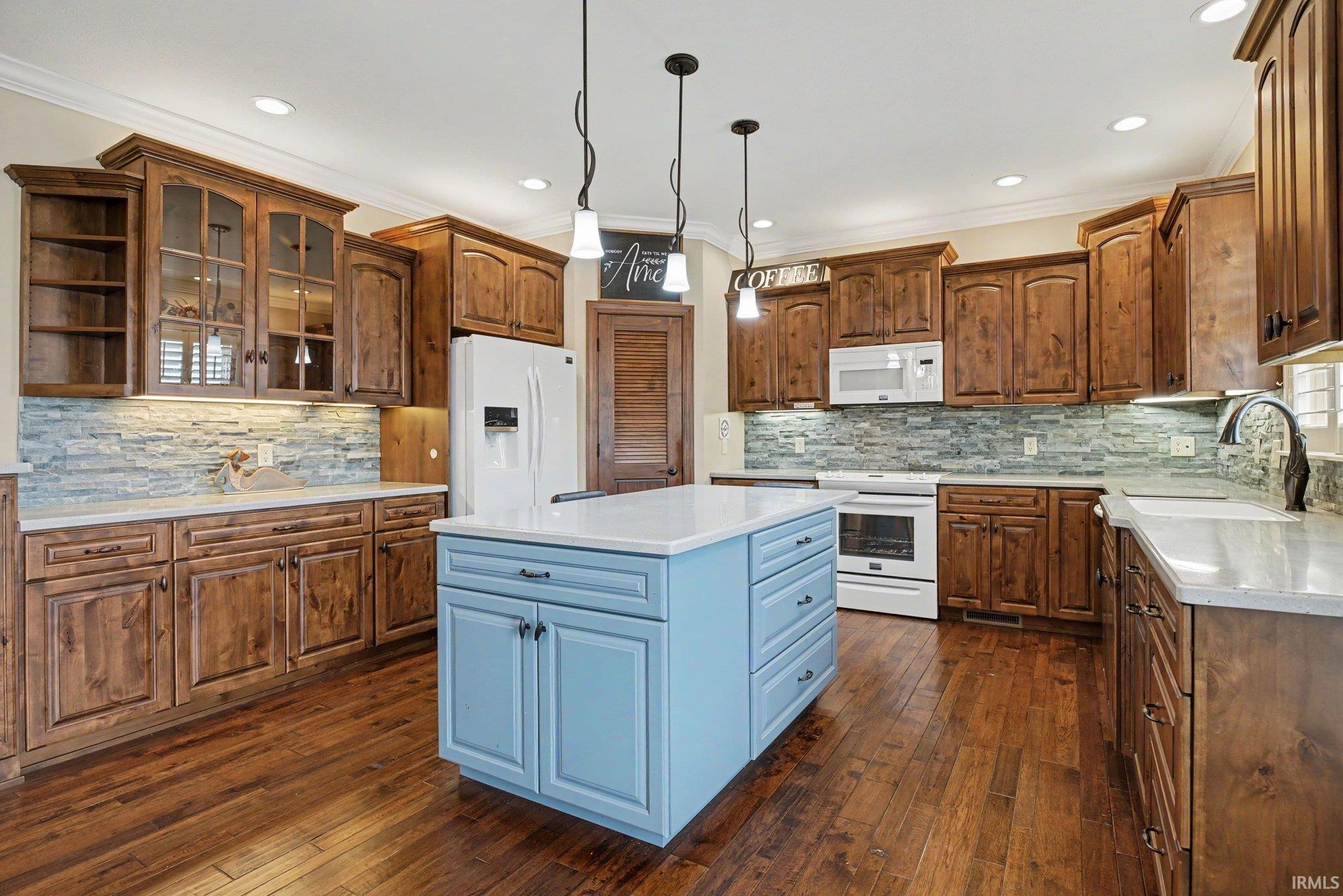 Expansive kitchen featuring a light blue central island with a white countertop