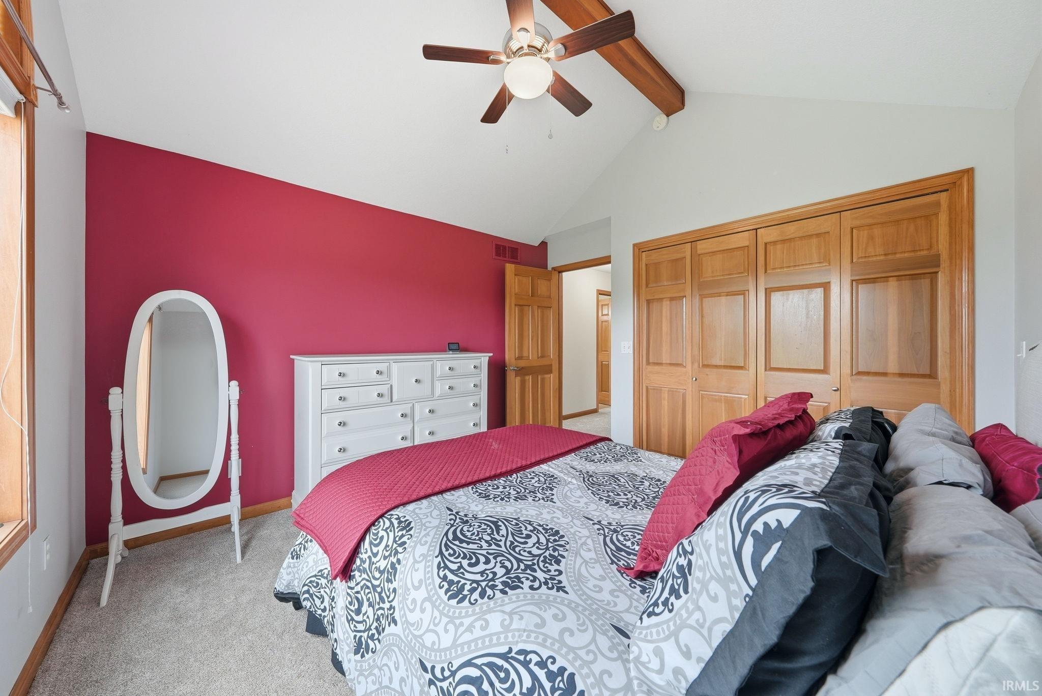 Vaulted ceiling featuring exposed wood beams and a ceiling fan