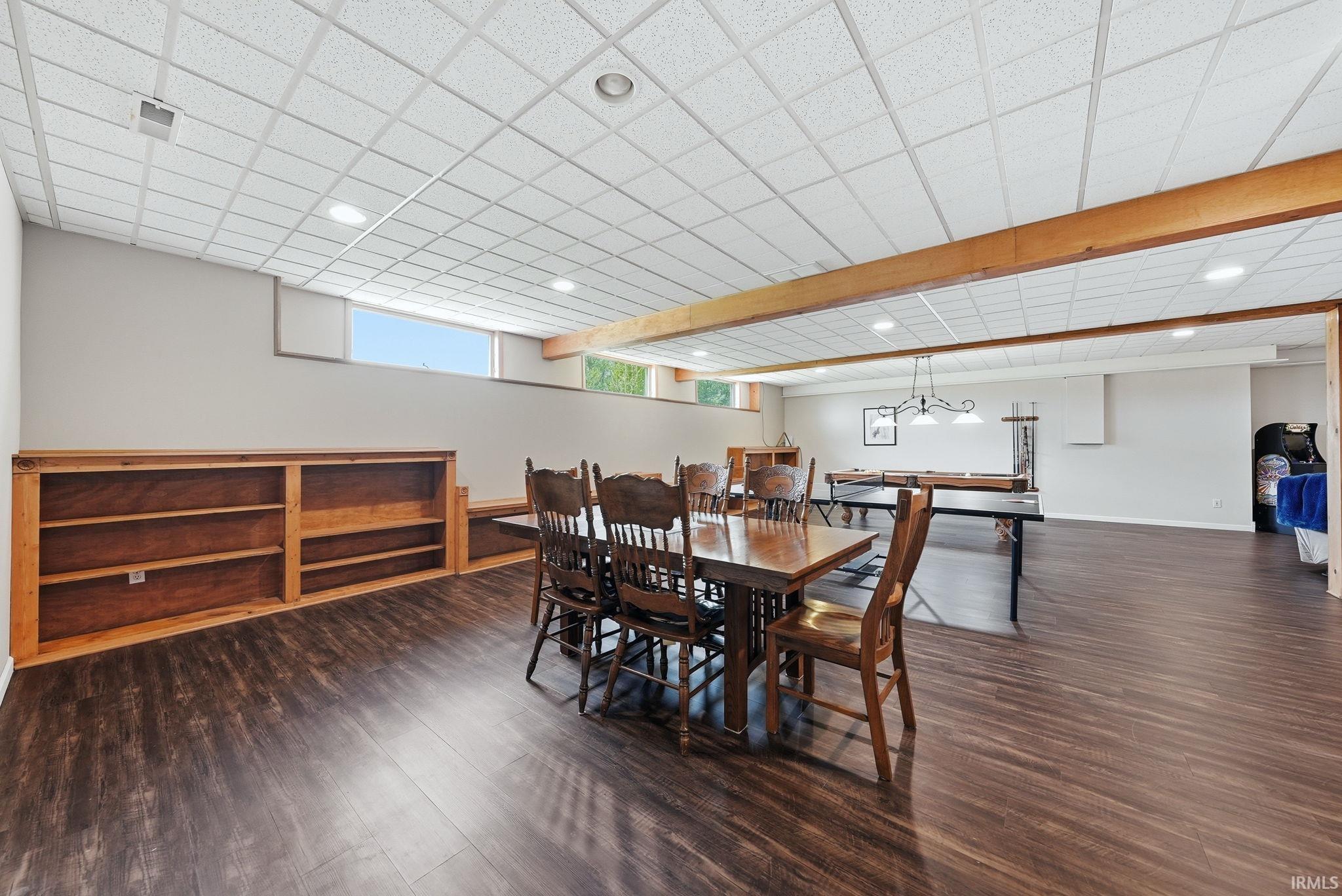 Spacious lower-level area featuring wood-finish flooring and a drop ceiling with recessed lighting