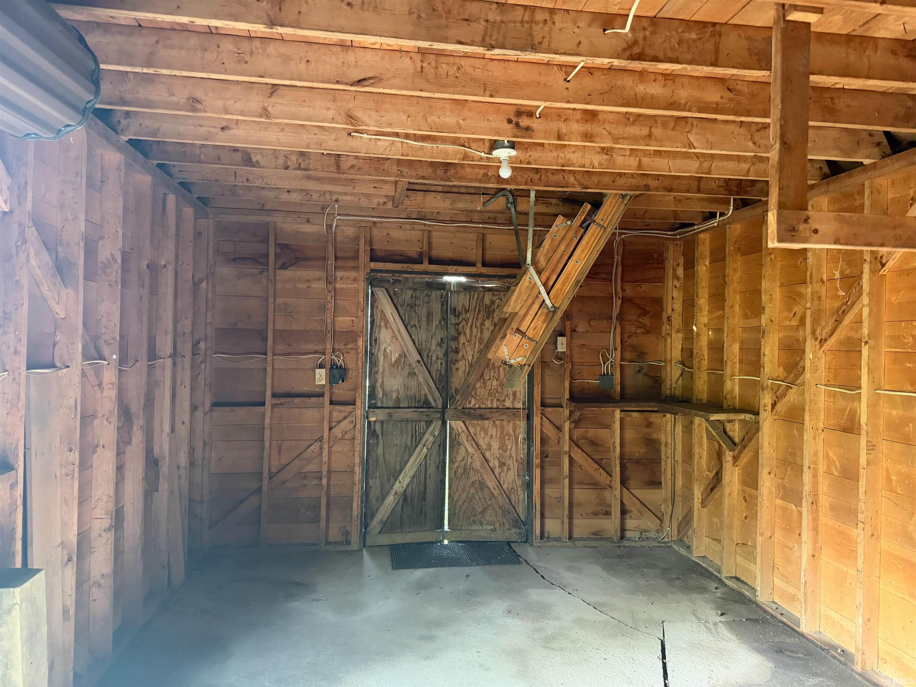 Interior space featuring exposed wood framing and a concrete floor