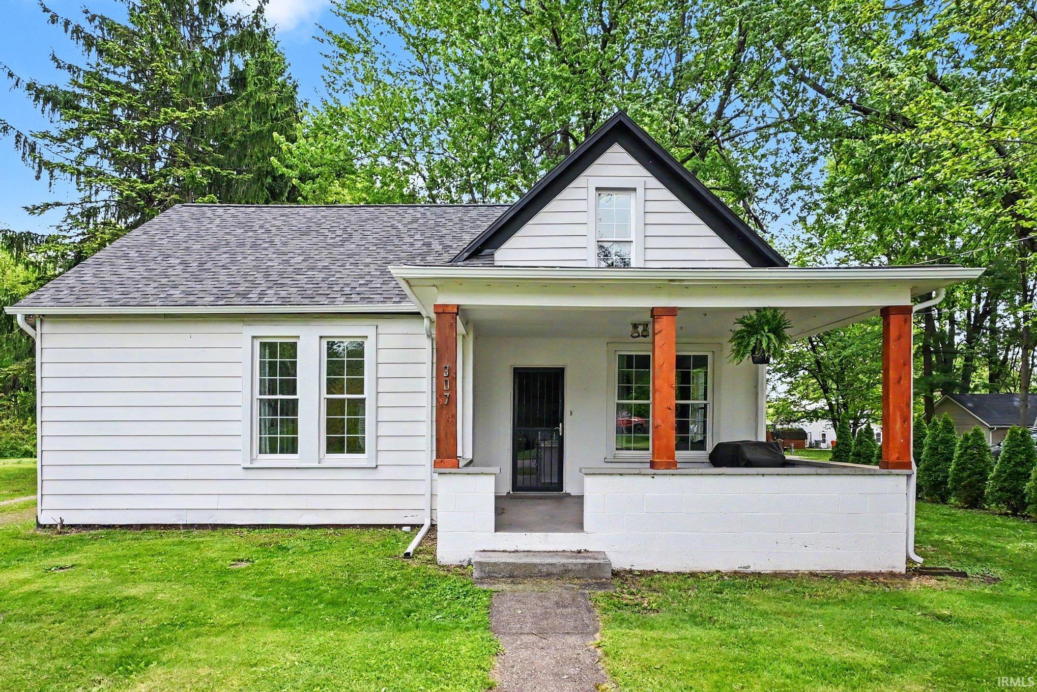 White siding exterior with a dark shingle roof and a covered front porch