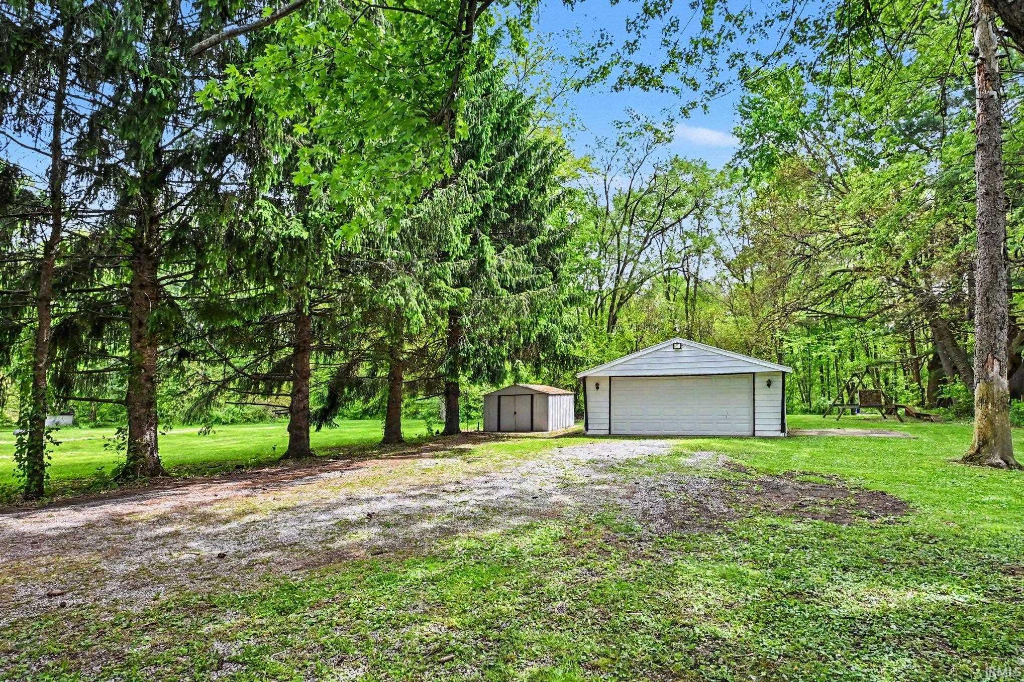 Detached two-car garage with white siding and dark trim