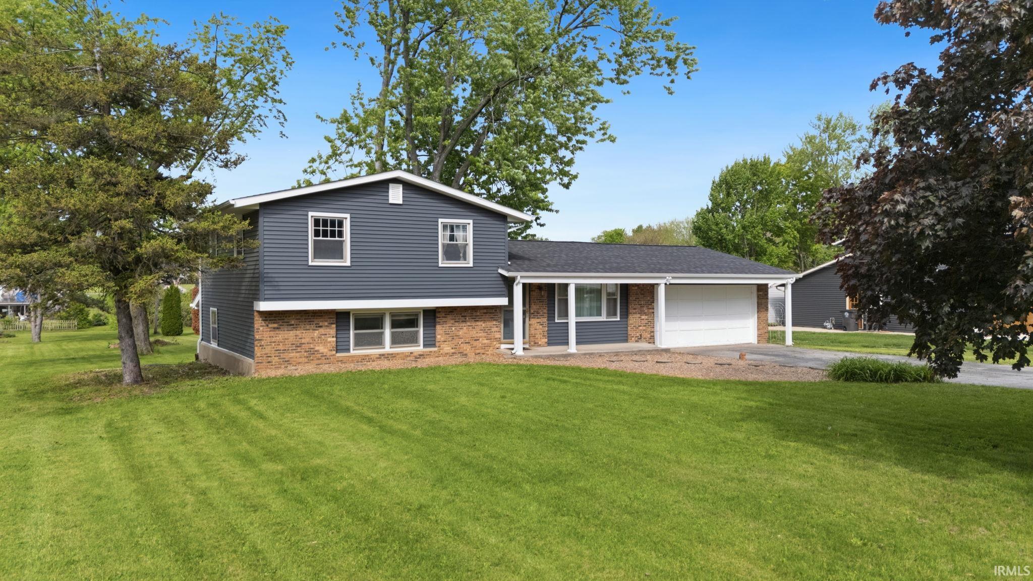 Two-story residence featuring blue siding and a brick-finish lower level