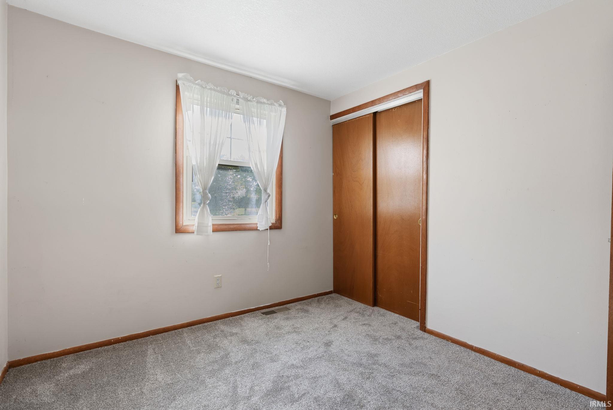 Neutral tone wall paint with wood-trim window and baseboards