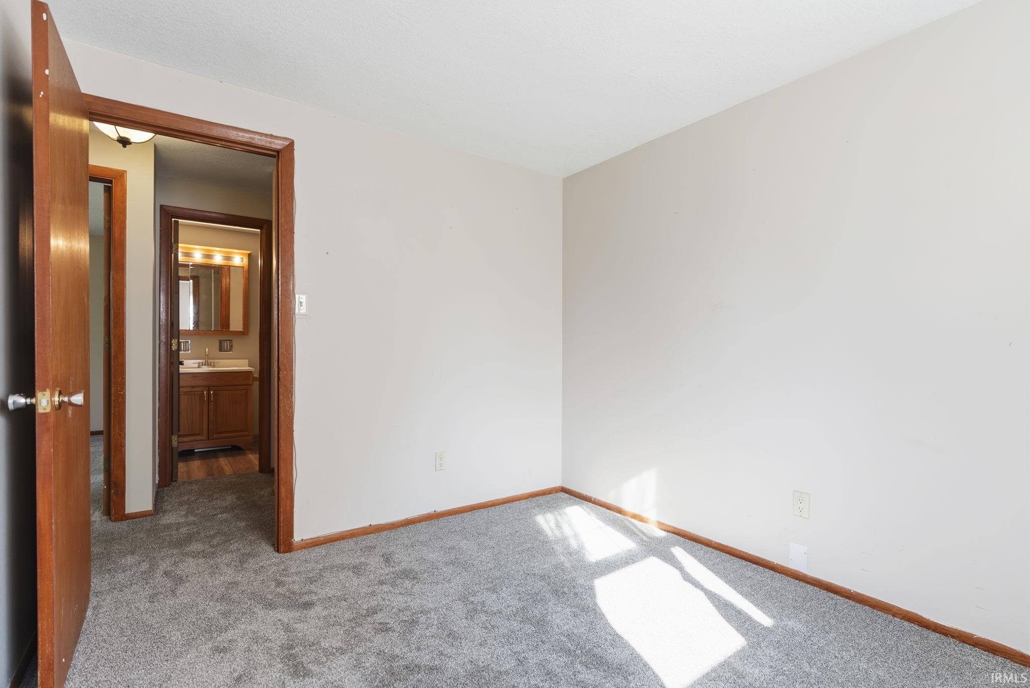 Soft gray wall paint and matching carpeting with natural wood trim