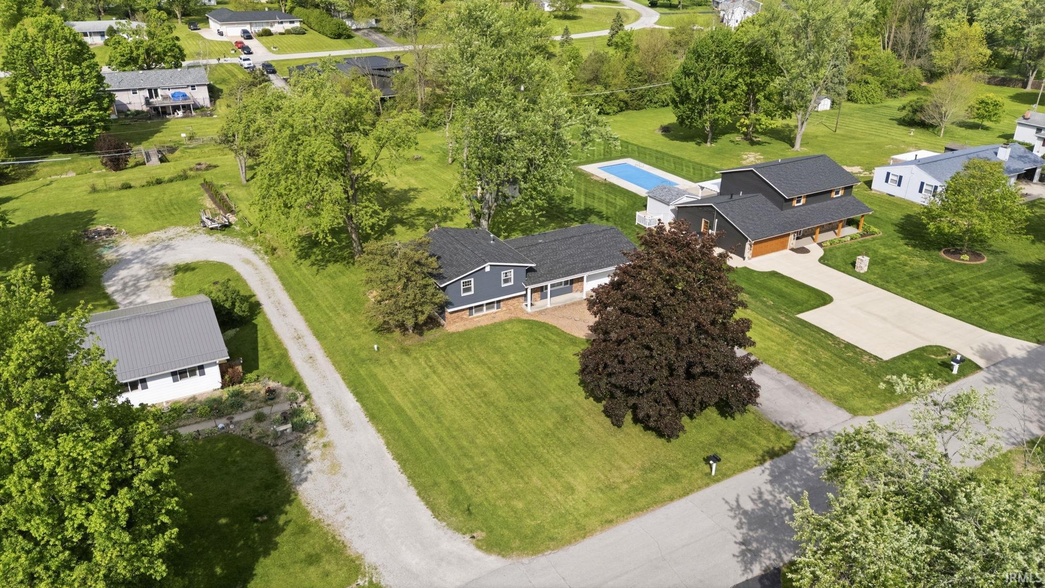 Ranch-style residence featuring a dark grey exterior, brick foundation, and a covered front porch