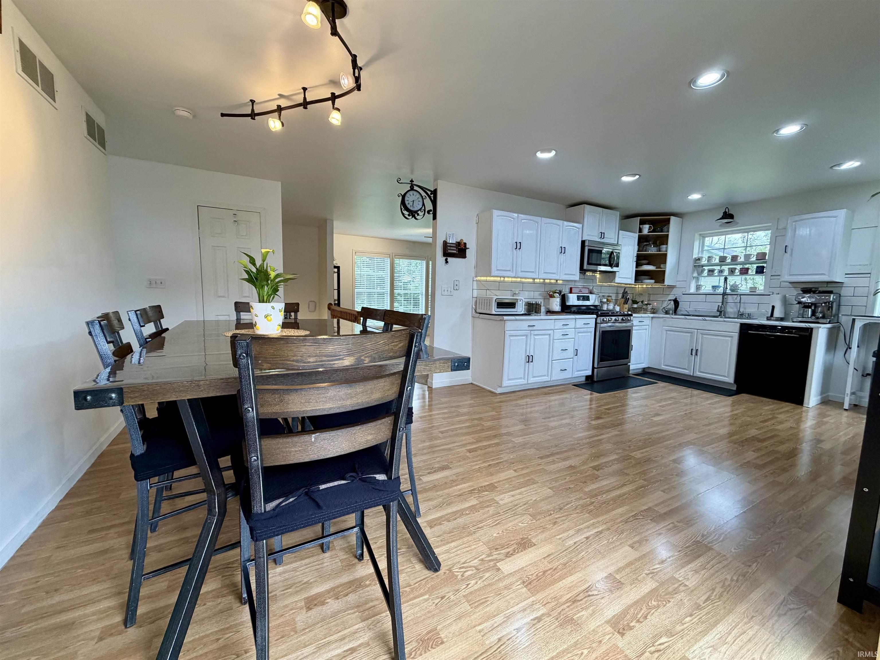 Open-concept kitchen and dining area featuring light wood-finish flooring