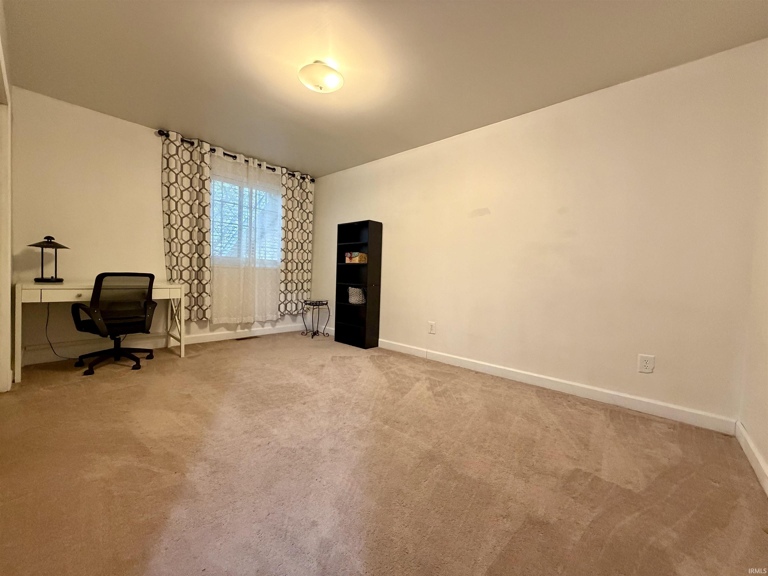 Carpeted room with a ceiling-mounted light fixture