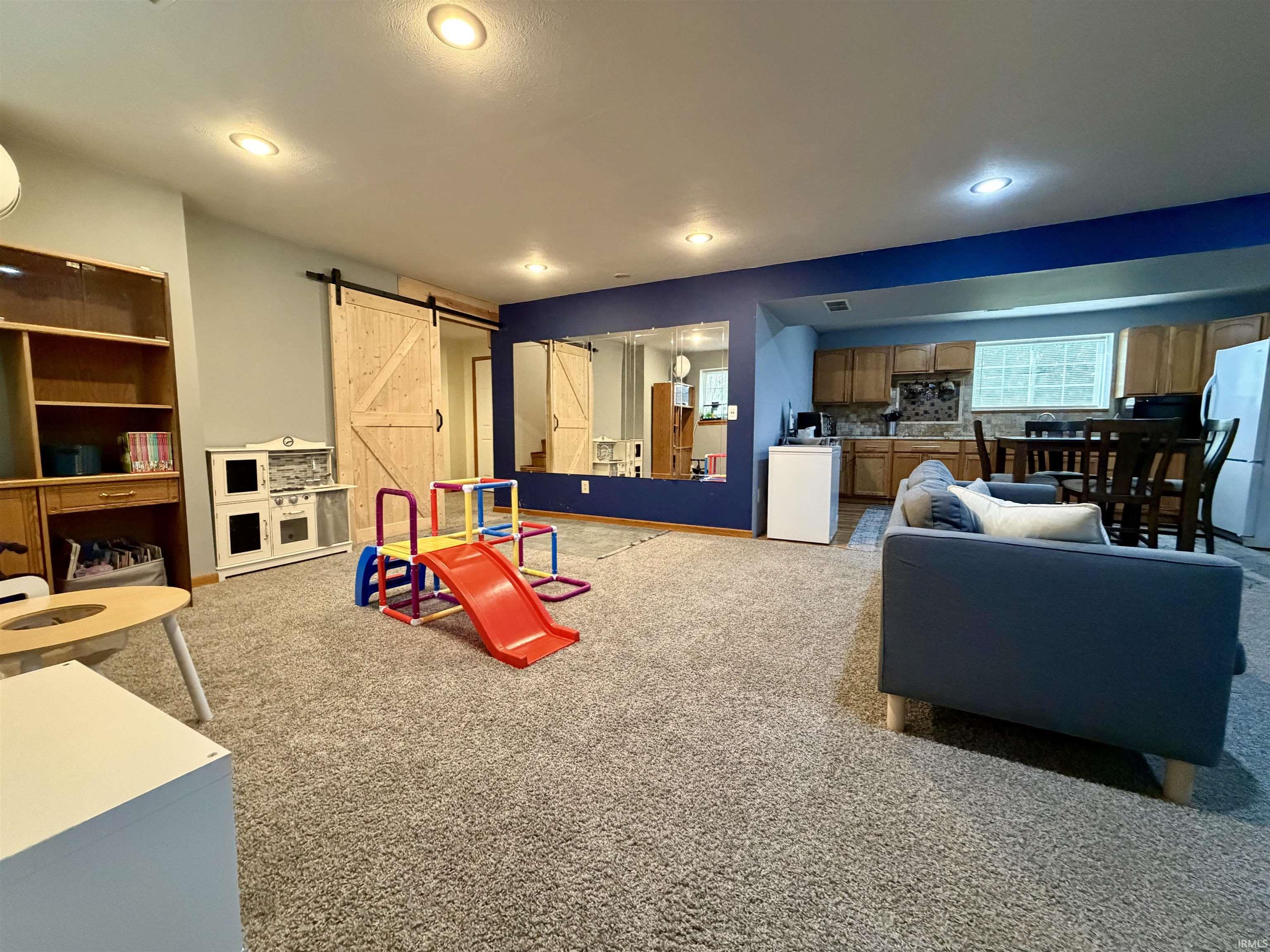Spacious lower level featuring recessed lighting, light-toned carpeting, and a built-in wooden shelving unit