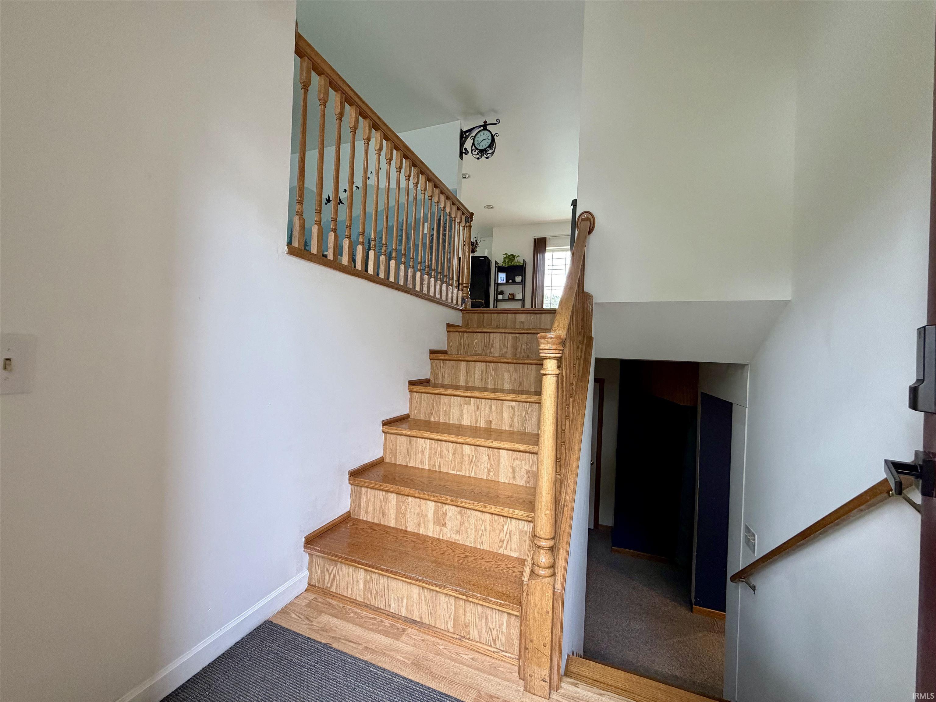 Hardwood staircase featuring a wood spindle railing and matching newel post