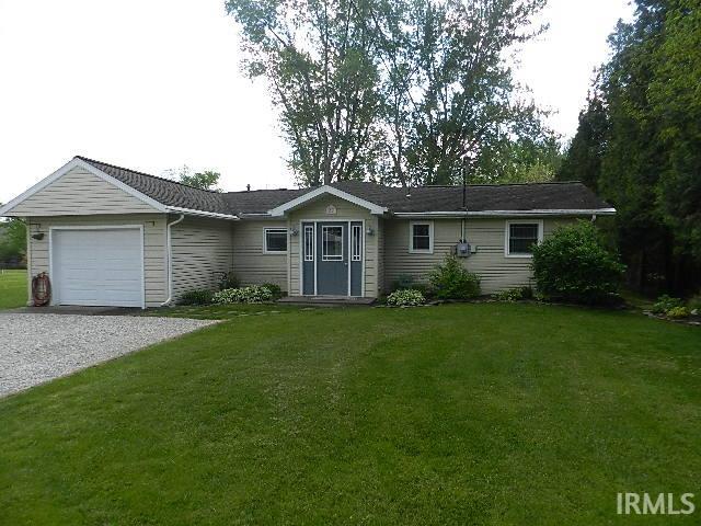 Siding exterior with attached single-car garage and gravel driveway