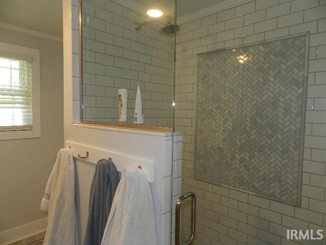 Glass-enclosed shower featuring subway tile walls and a recessed herringbone tile accent