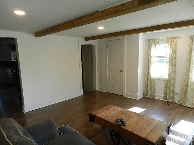 Living area featuring wood-finish flooring, white shiplap ceiling with exposed wood beams, and recessed lighting