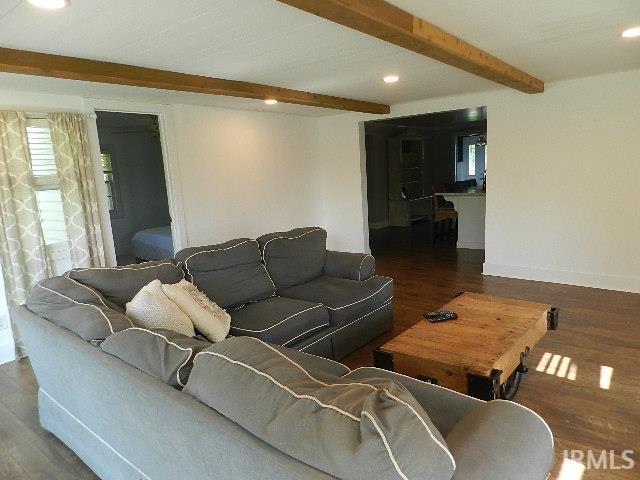 Living area featuring wood-finish flooring, exposed ceiling beams, recessed lighting, and white walls