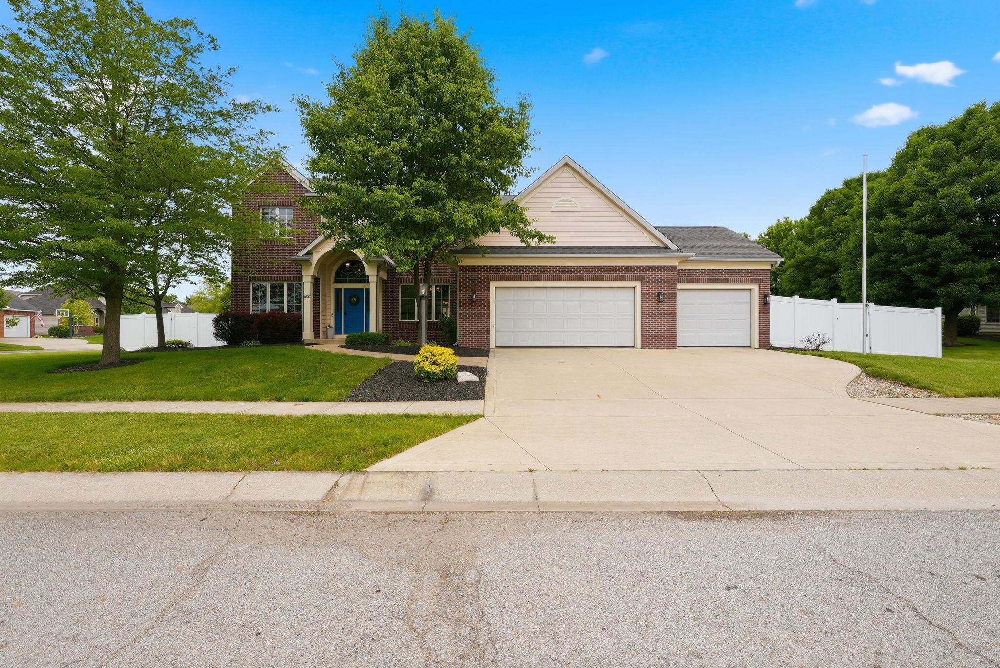 Brick exterior with a prominent arched entry, two-car garage, and a separate one-car garage