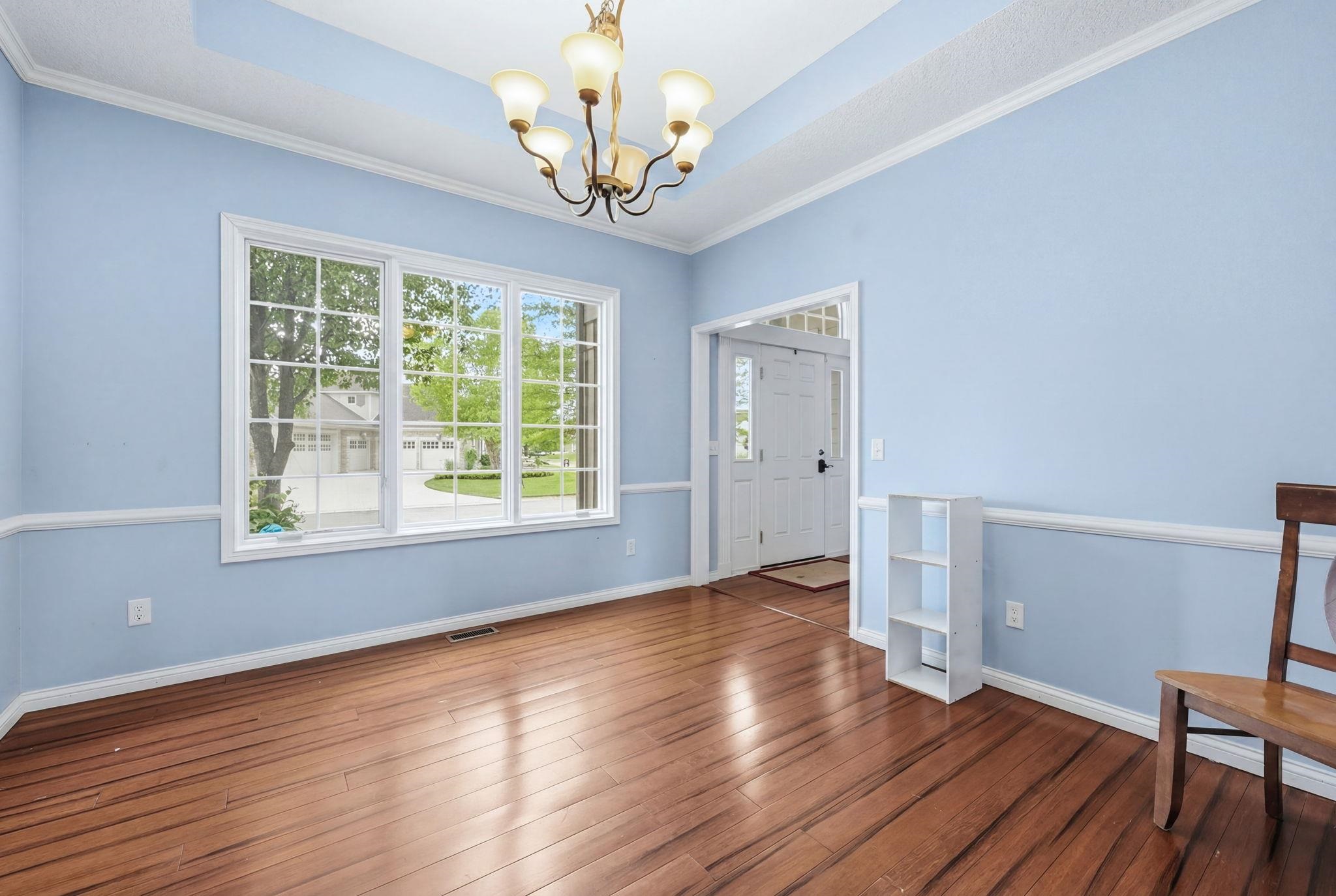 Hardwood flooring in a room with light blue walls and white trim