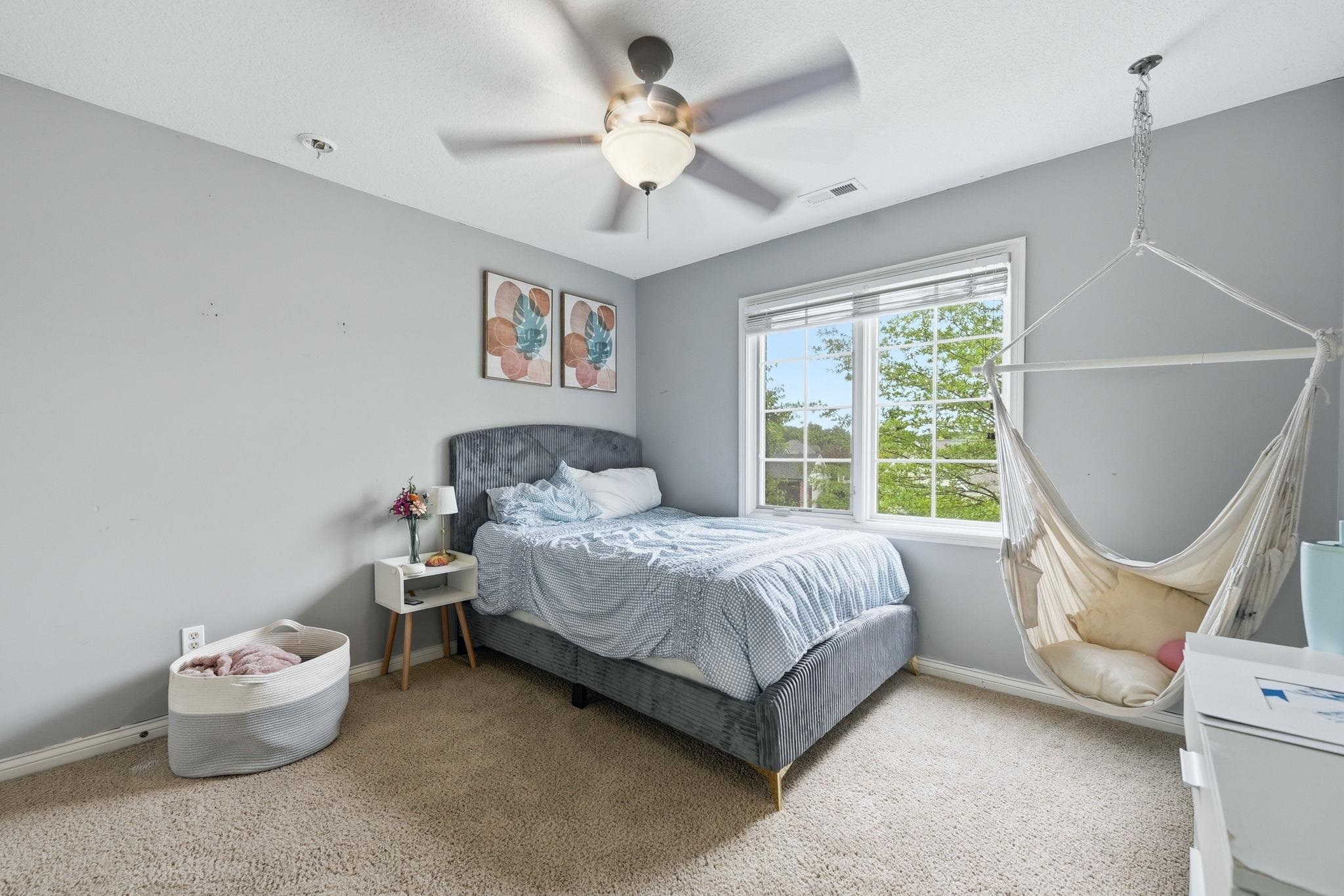 Carpeted room with a ceiling fan, a double window, and light gray walls