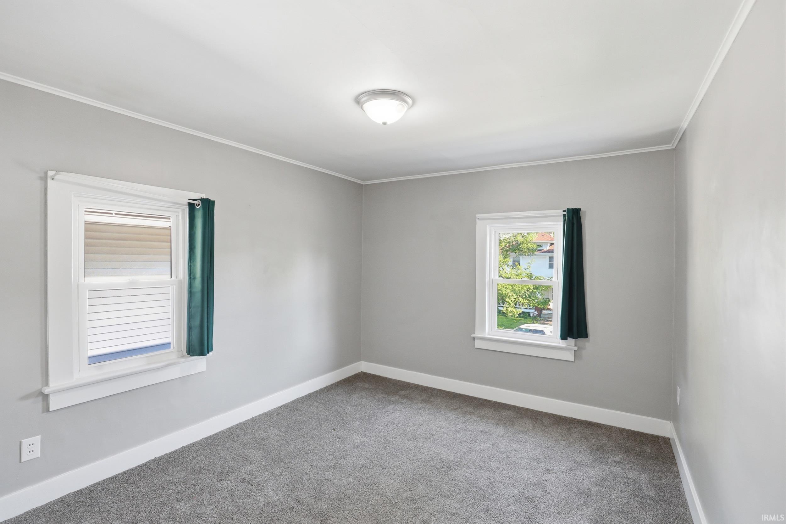 Room featuring light gray painted walls, white trim, and gray carpeted flooring