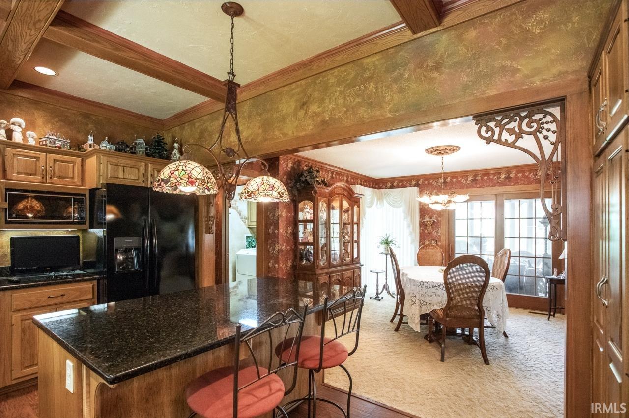 Kitchen island with a dark granite countertop and a Tiffany-style pendant light fixture