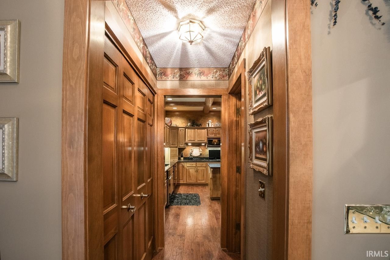 Hallway featuring wood-finish flooring and solid wood panel doors