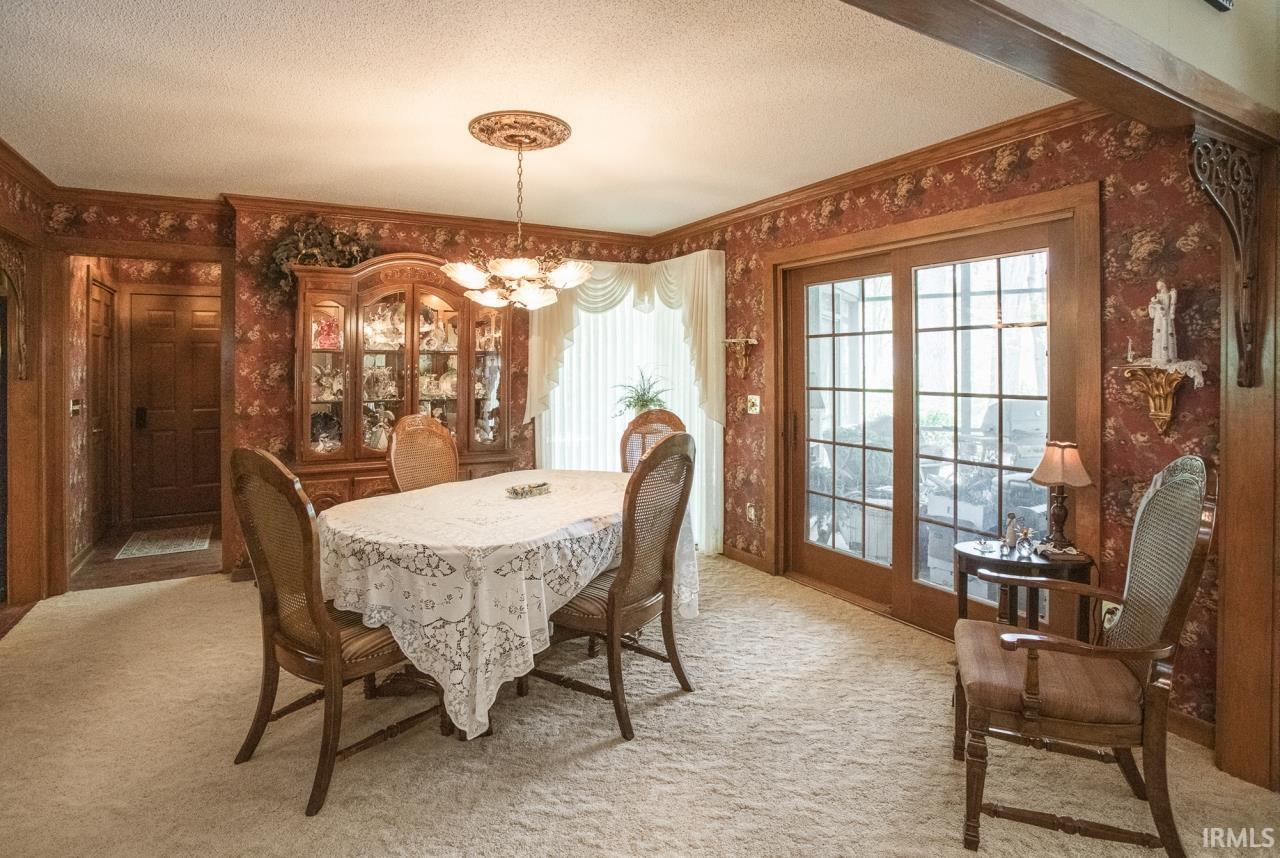Dining area featuring a decorative ceiling medallion, a multi-light chandelier, and full-light patio doors