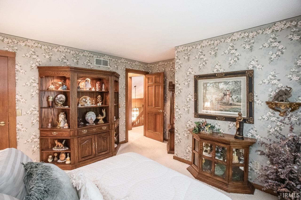 Warm-toned wood doors and trim complement floral-patterned wallpaper