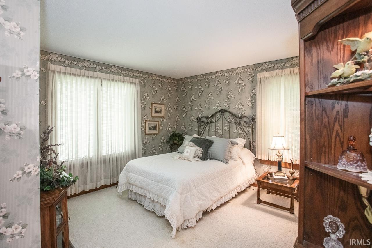 Room featuring light-colored carpeting and patterned wallpaper
