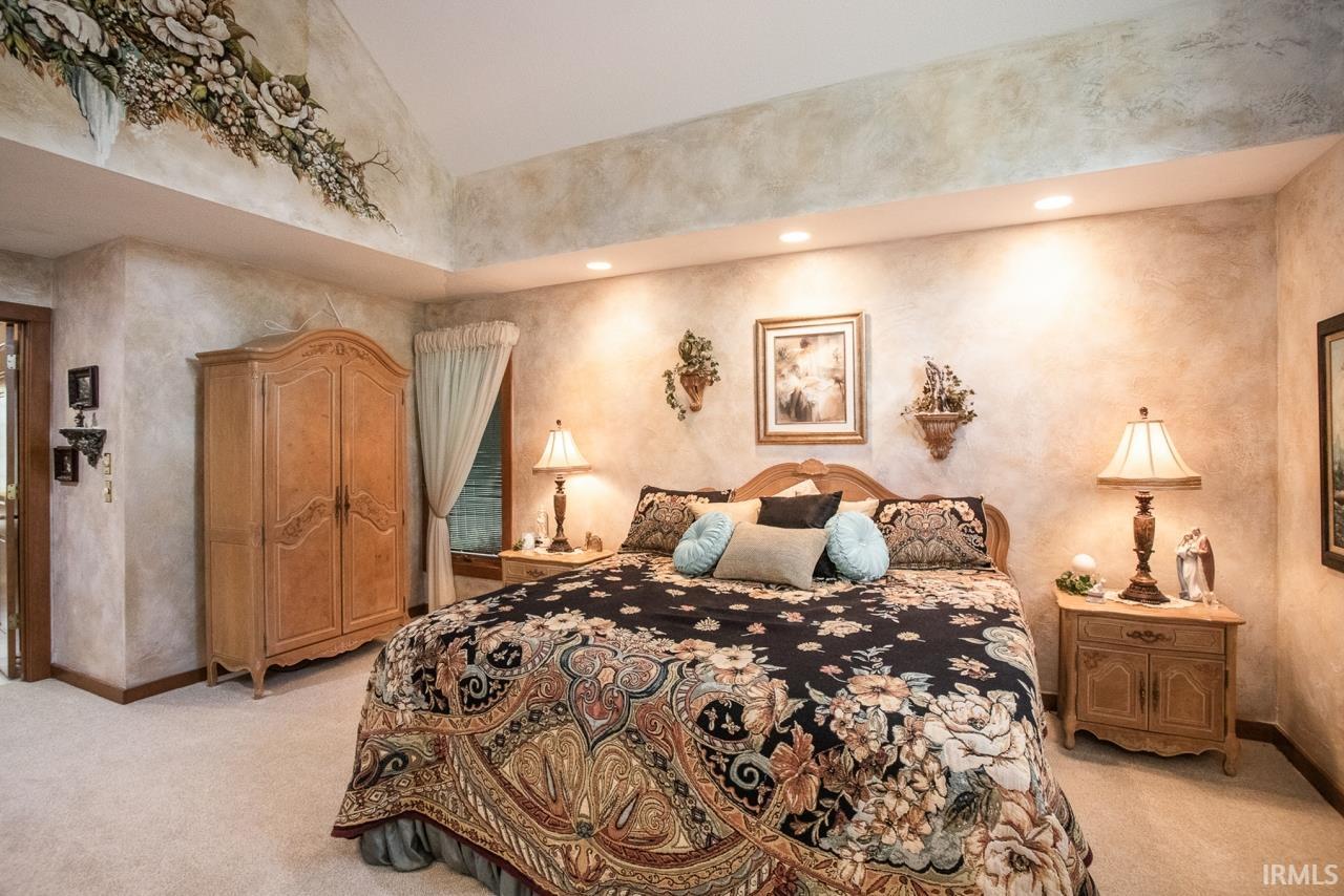 Bedroom with vaulted ceiling featuring painted floral accents