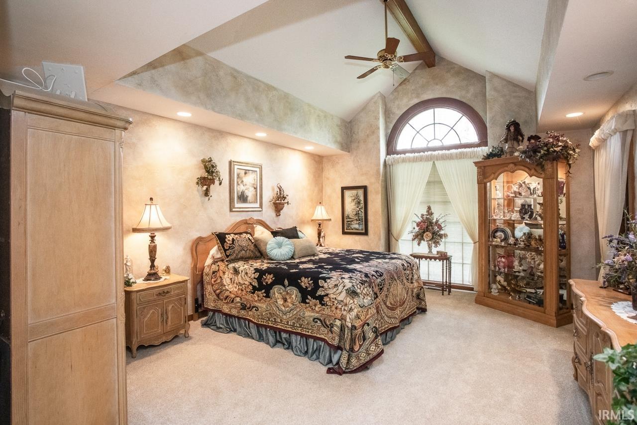 Vaulted ceiling featuring a wood beam and ceiling fan